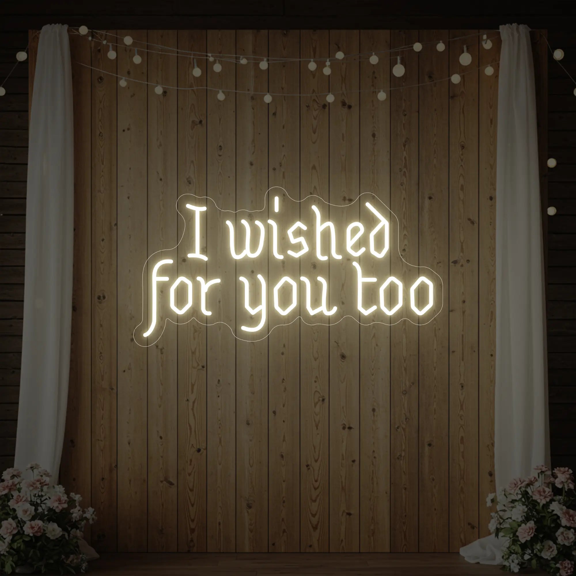 Photo of the 'I Wished For You Too' neon sign glowing in warm white against a styled interior wall.