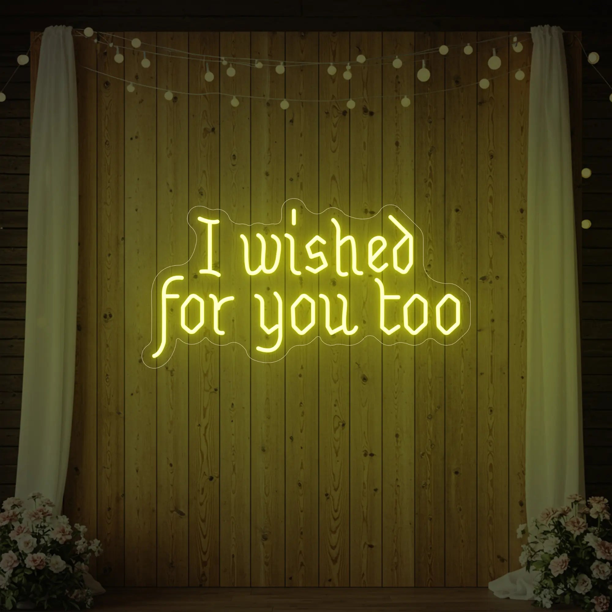 Photo of the 'I Wished For You Too' neon sign glowing in lemon yellow against a styled interior wall.