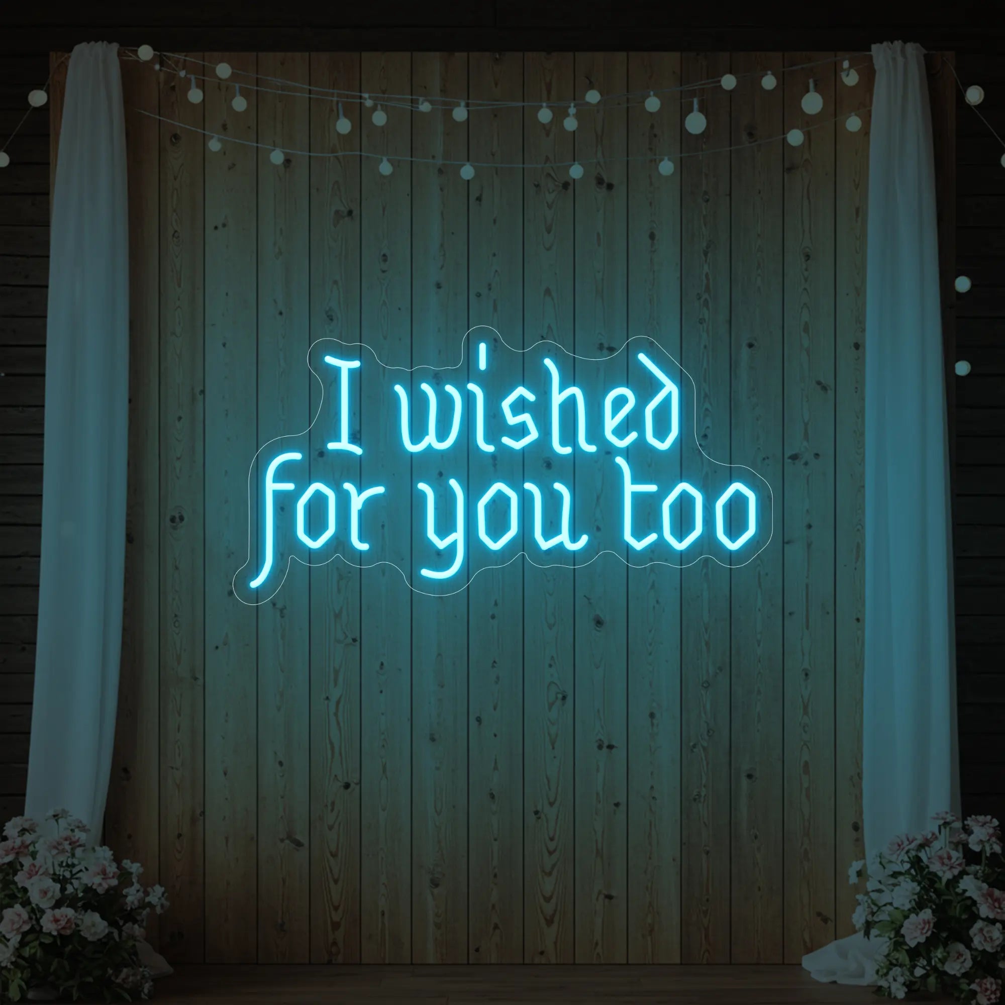 Photo of the 'I Wished For You Too' neon sign glowing in ice blue against a styled interior wall.