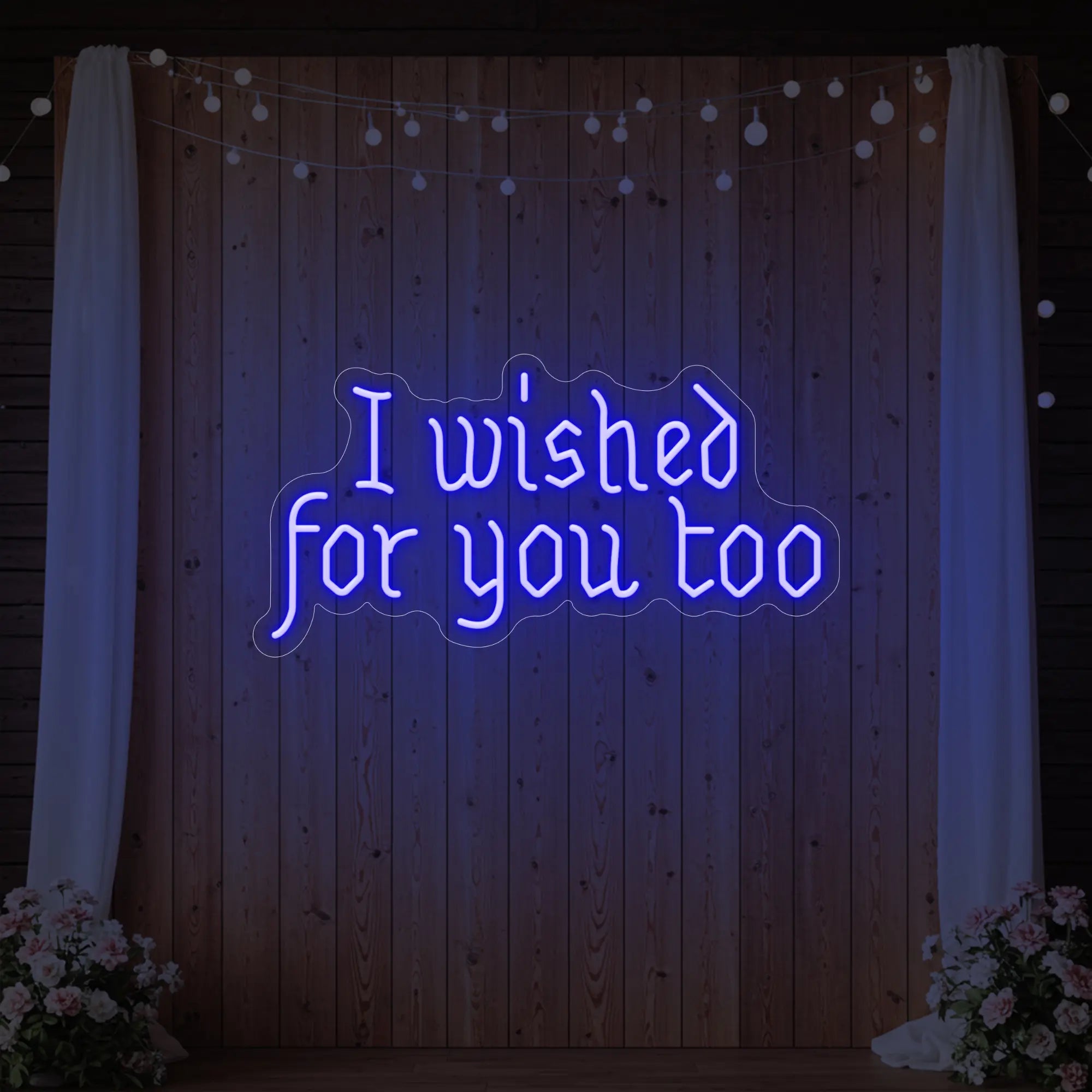 Photo of the 'I Wished For You Too' neon sign glowing in deep blue against a styled interior wall.
