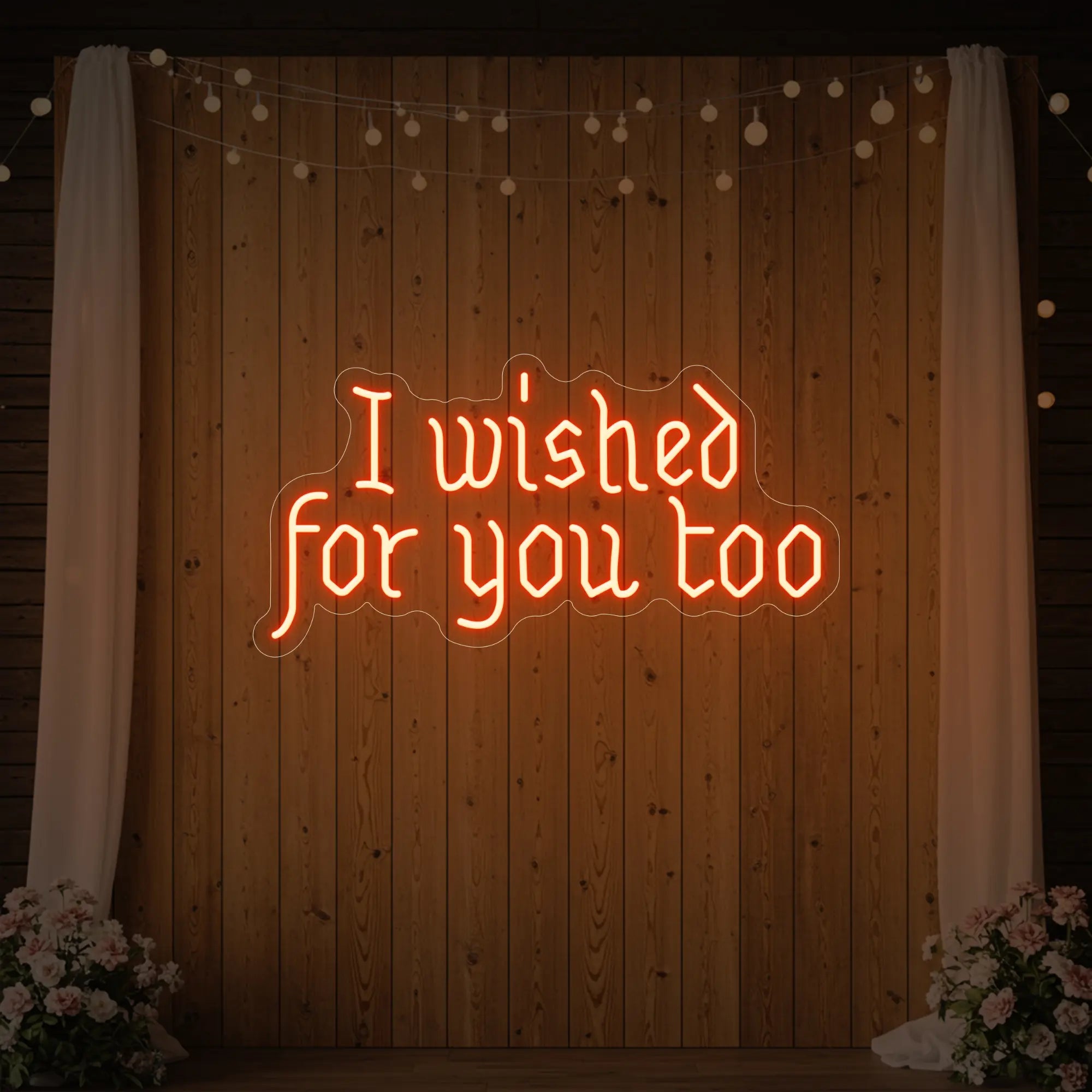 Photo of the 'I Wished For You Too' neon sign glowing in golden yellow against a styled interior wall.
