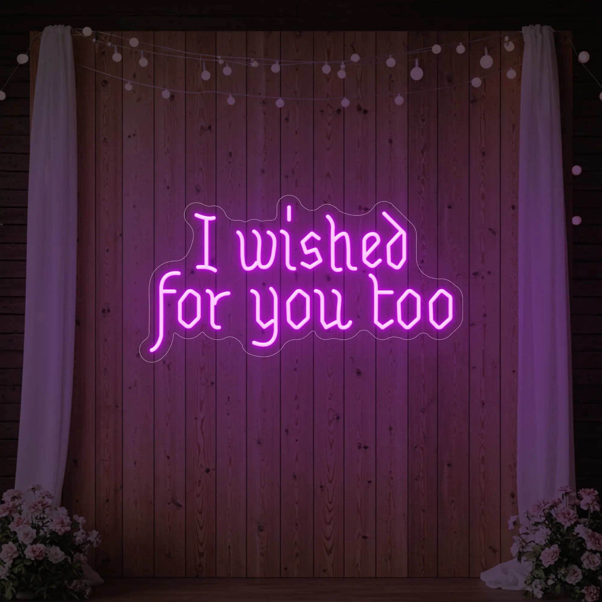 Photo of the 'I Wished For You Too' neon sign glowing in deep pink against a styled interior wall.