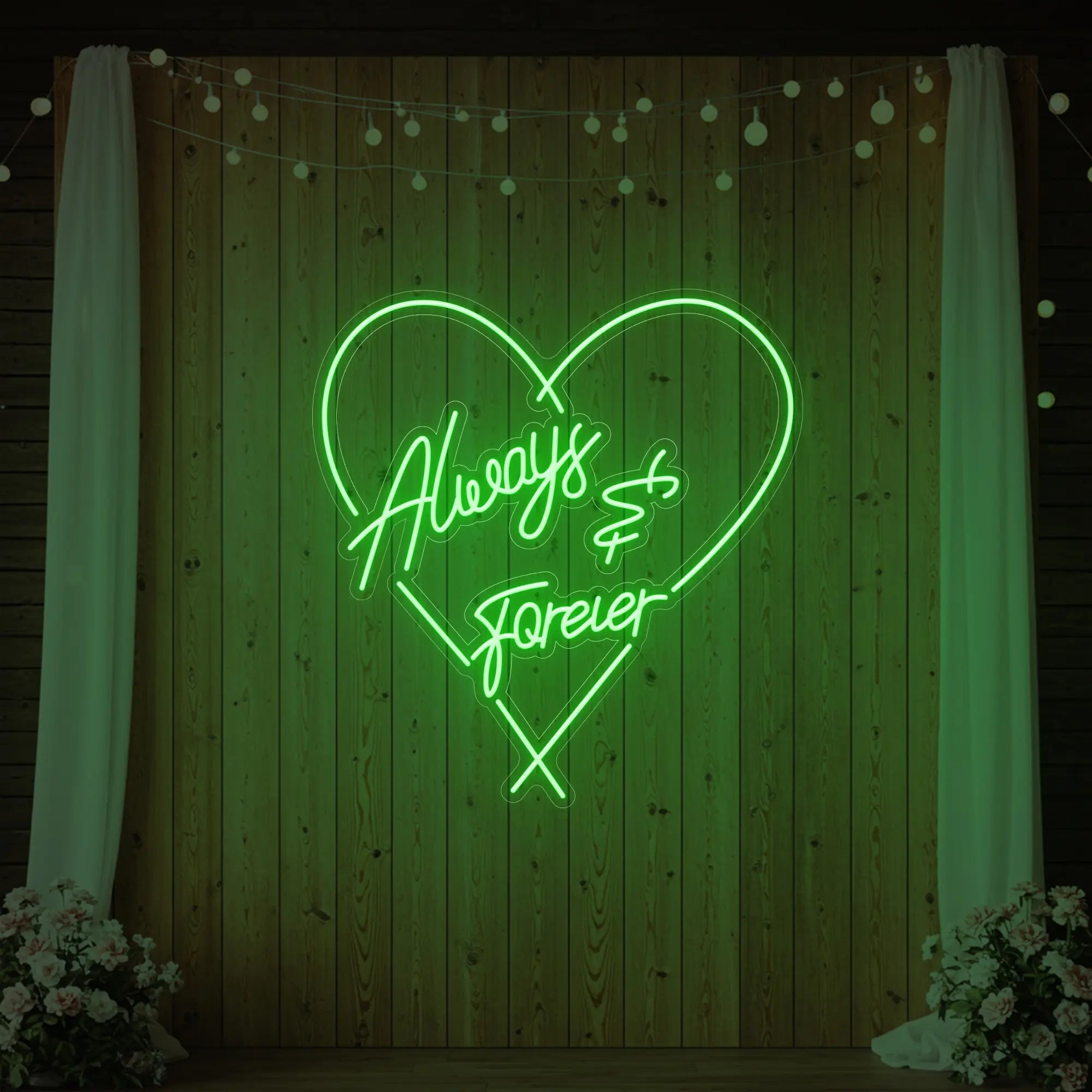 Photo of the 'Always & Forever' neon sign glowing in green against a styled interior wall.