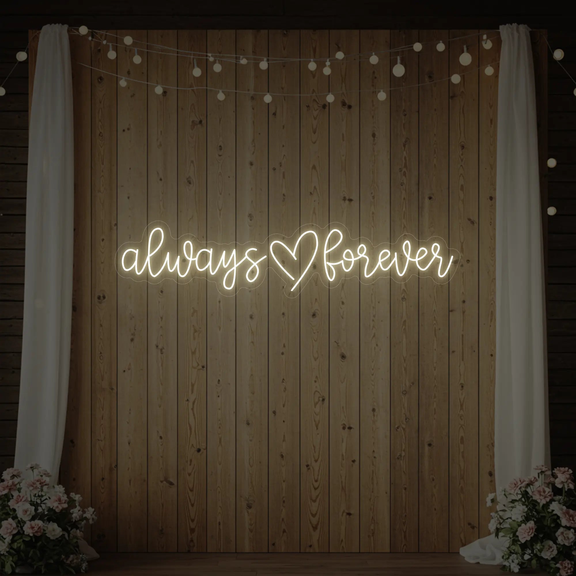 Photo of the 'Always Heart Forever' neon sign glowing in warm white against a styled interior wall.