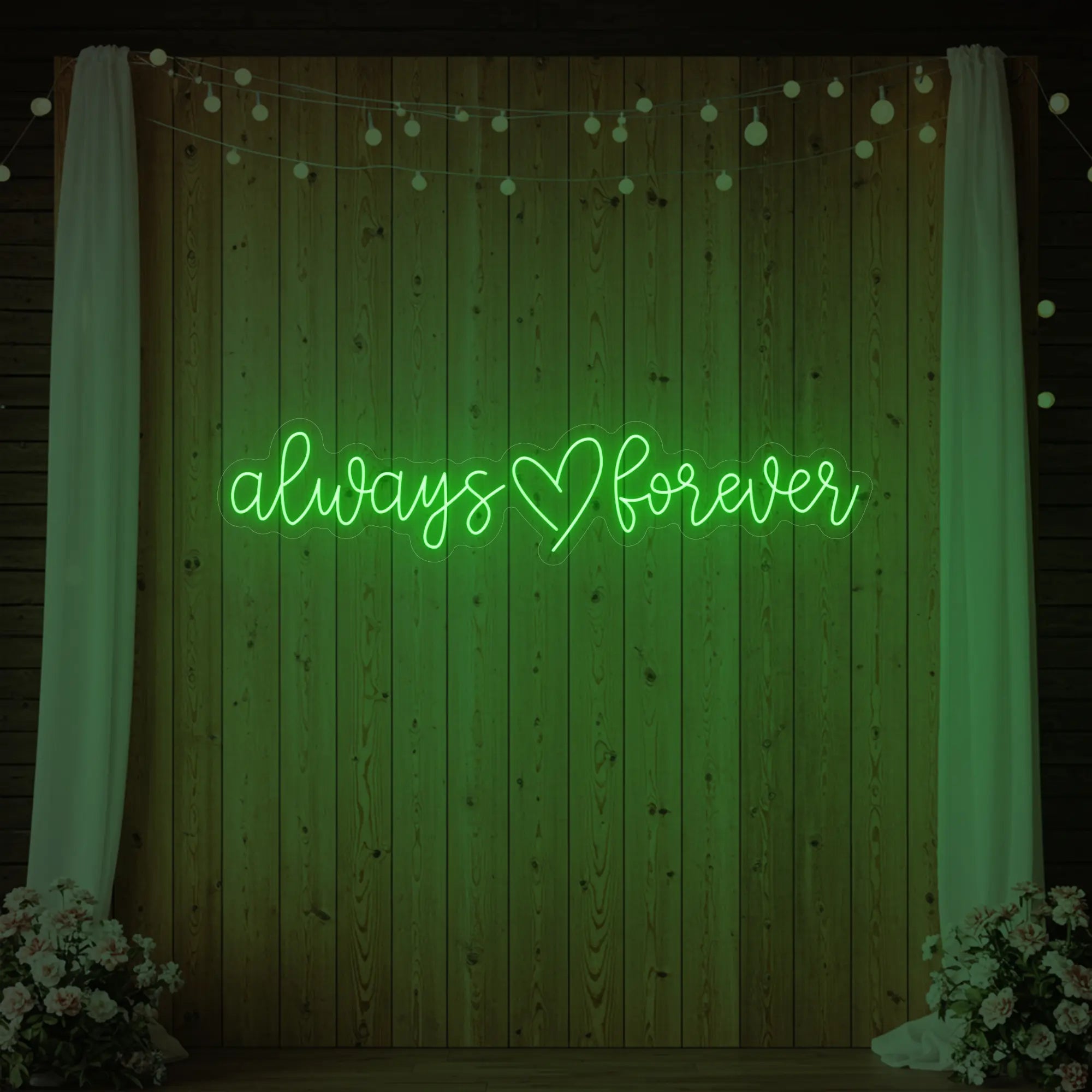 Photo of the 'Always Heart Forever' neon sign glowing in green against a styled interior wall.