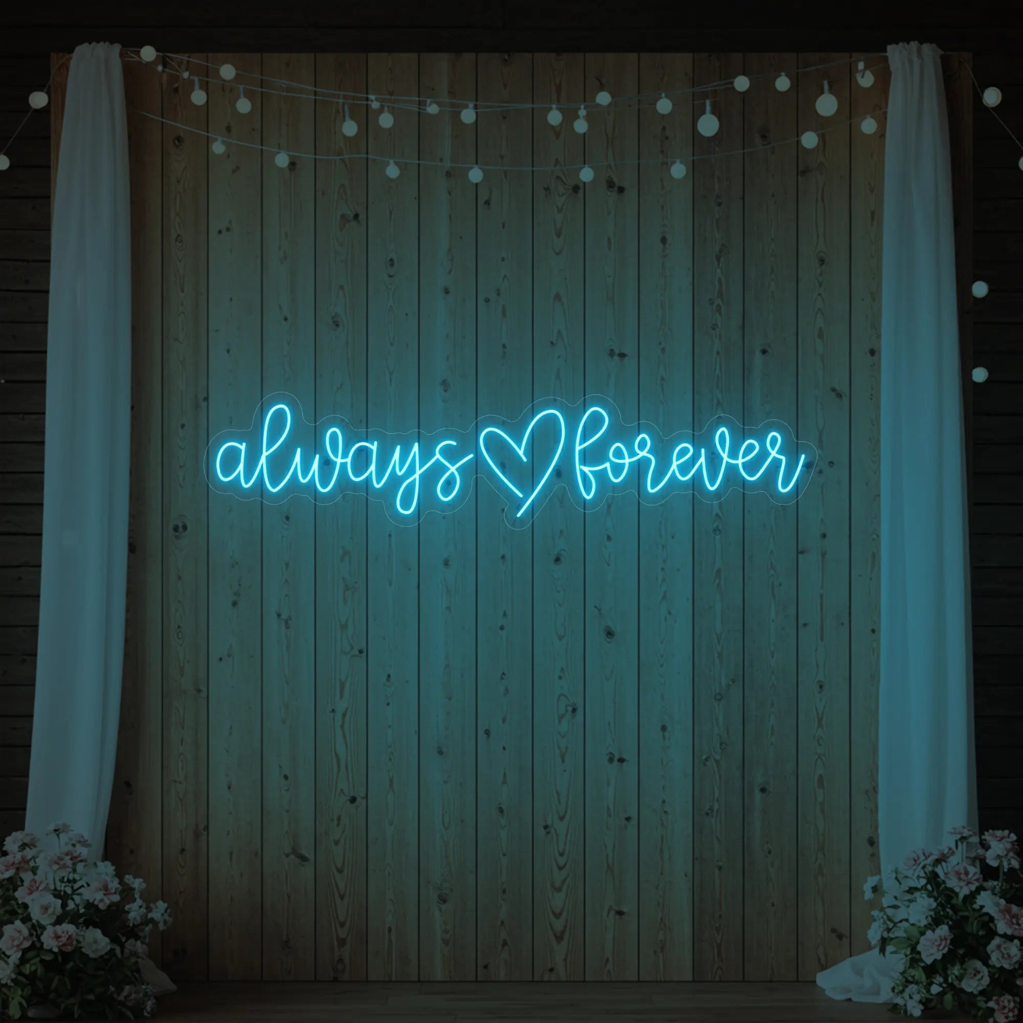 Photo of the 'Always Heart Forever' neon sign glowing in ice blue against a styled interior wall.