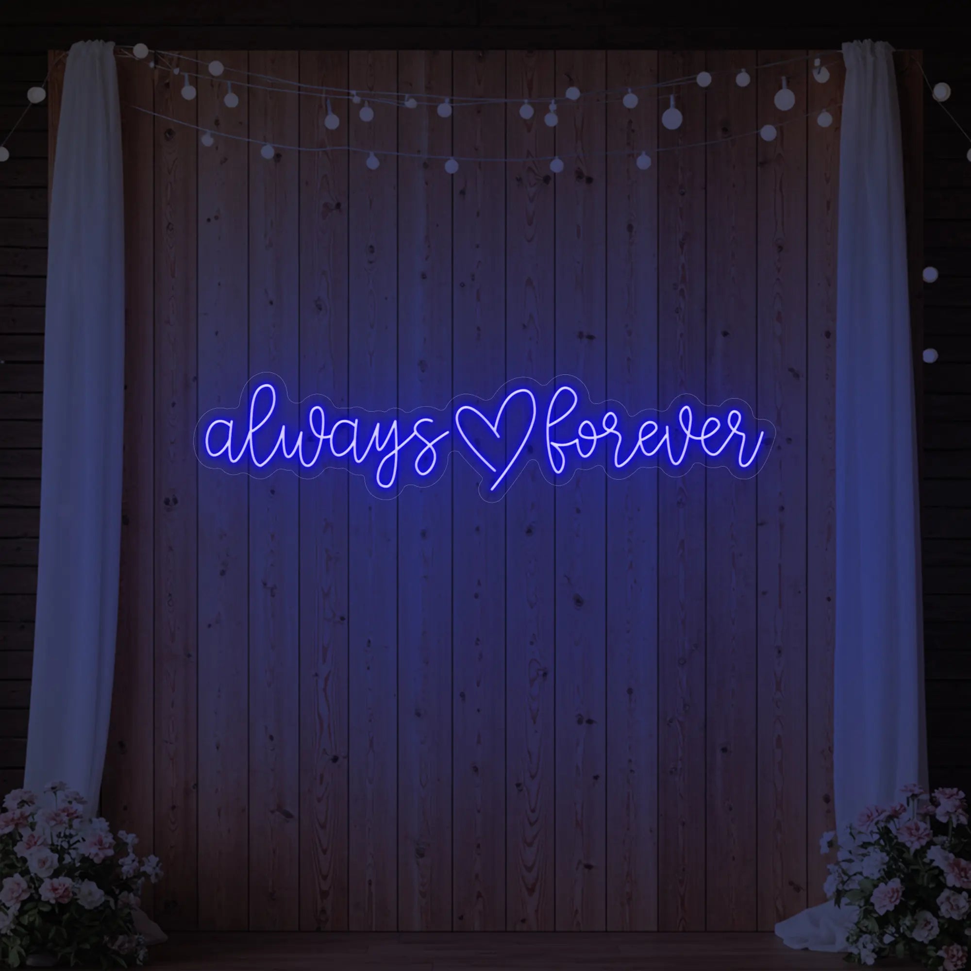 Photo of the 'Always Heart Forever' neon sign glowing in deep blue against a styled interior wall.