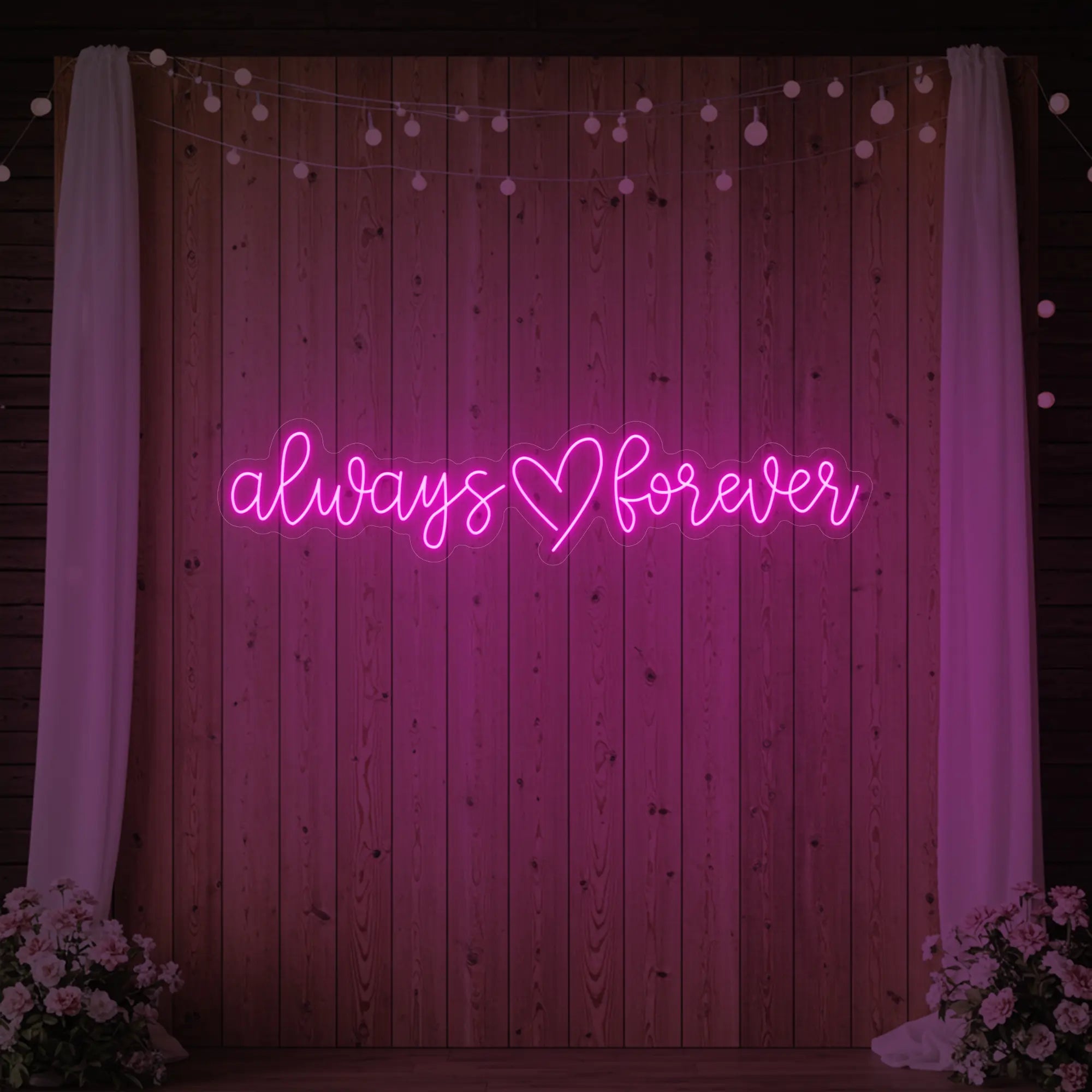 Photo of the 'Always Heart Forever' neon sign glowing in light pink against a styled interior wall.