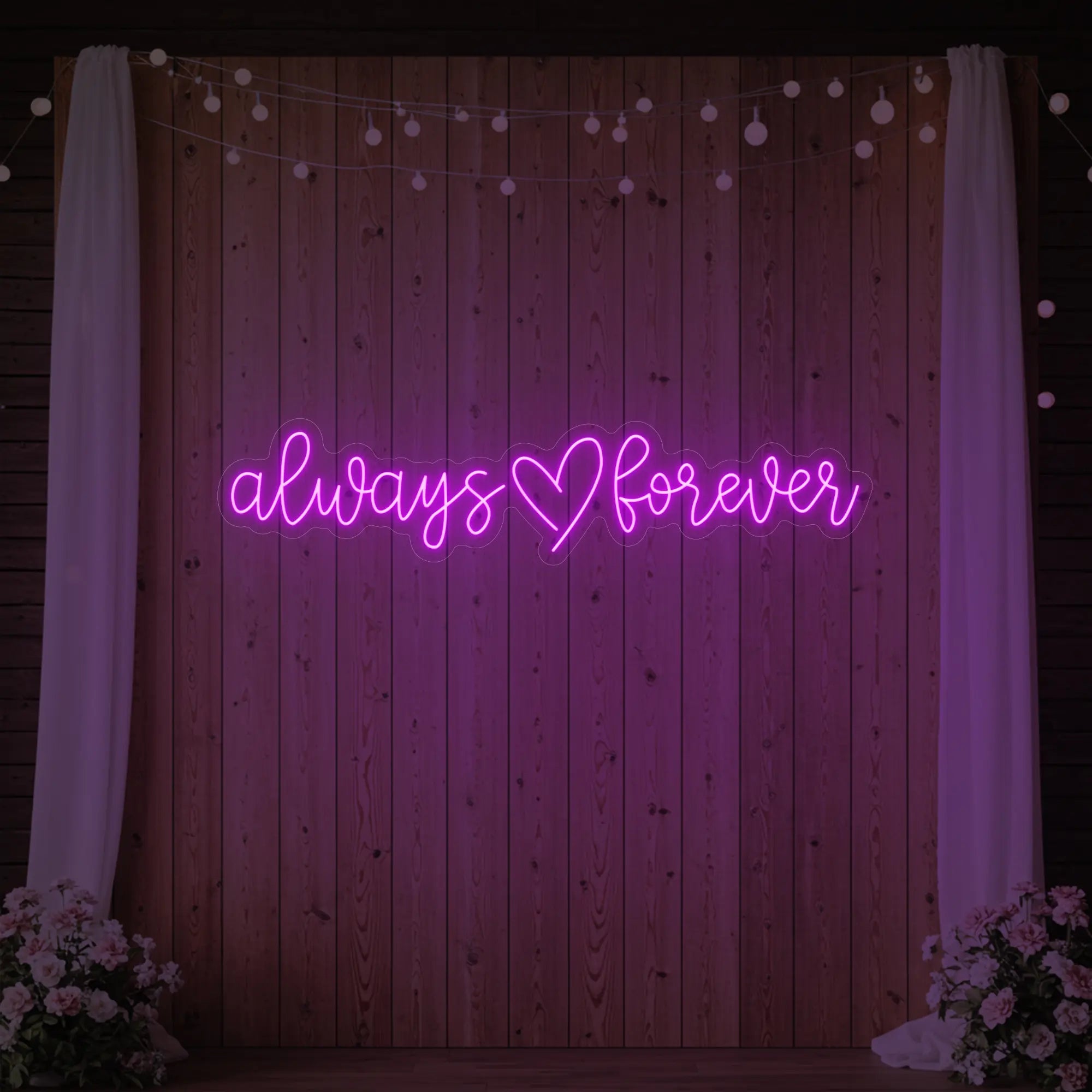 Photo of the 'Always Heart Forever' neon sign glowing in deep pink against a styled interior wall.