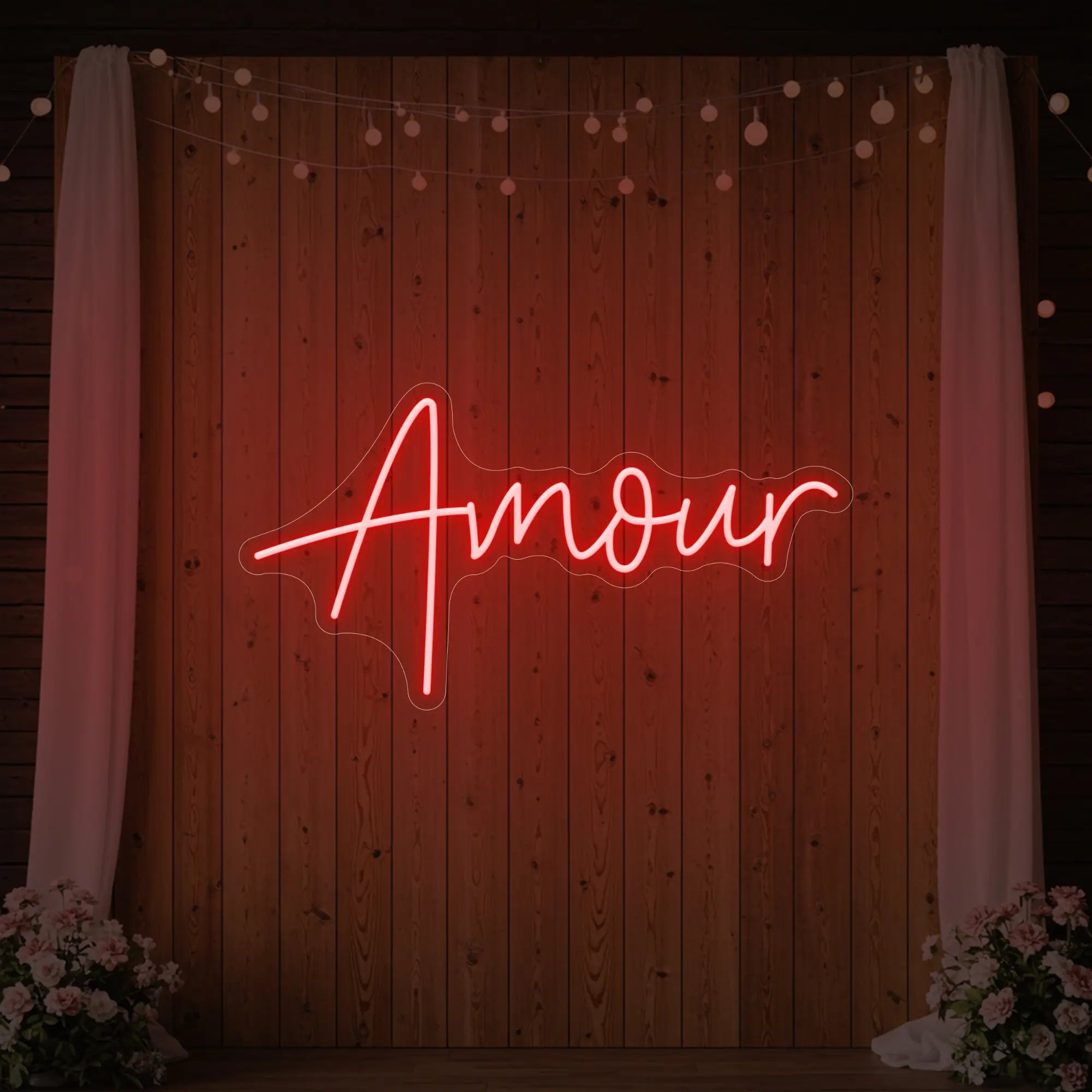 Photo of the 'Amour' neon sign glowing in red against a styled interior wall.
