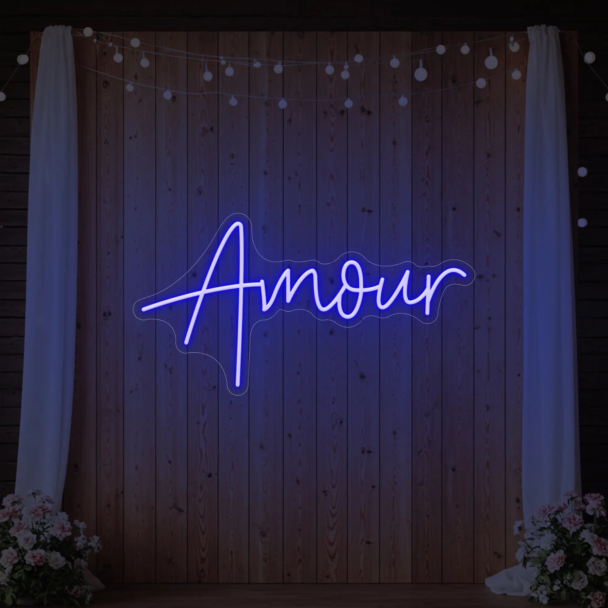 Photo of the 'Amour' neon sign glowing in deep blue against a styled interior wall.