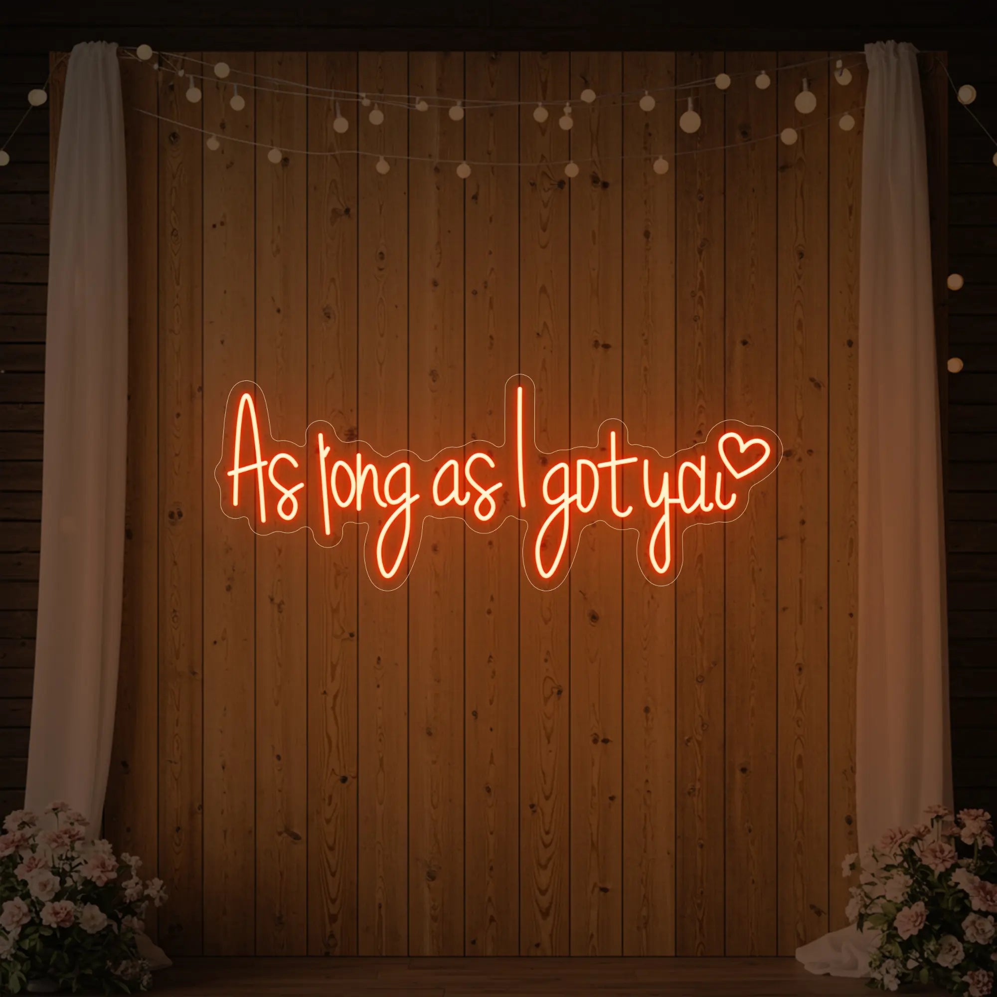 Photo of the 'As Long As I Got You' neon sign glowing in golden yellow against a styled interior wall.
