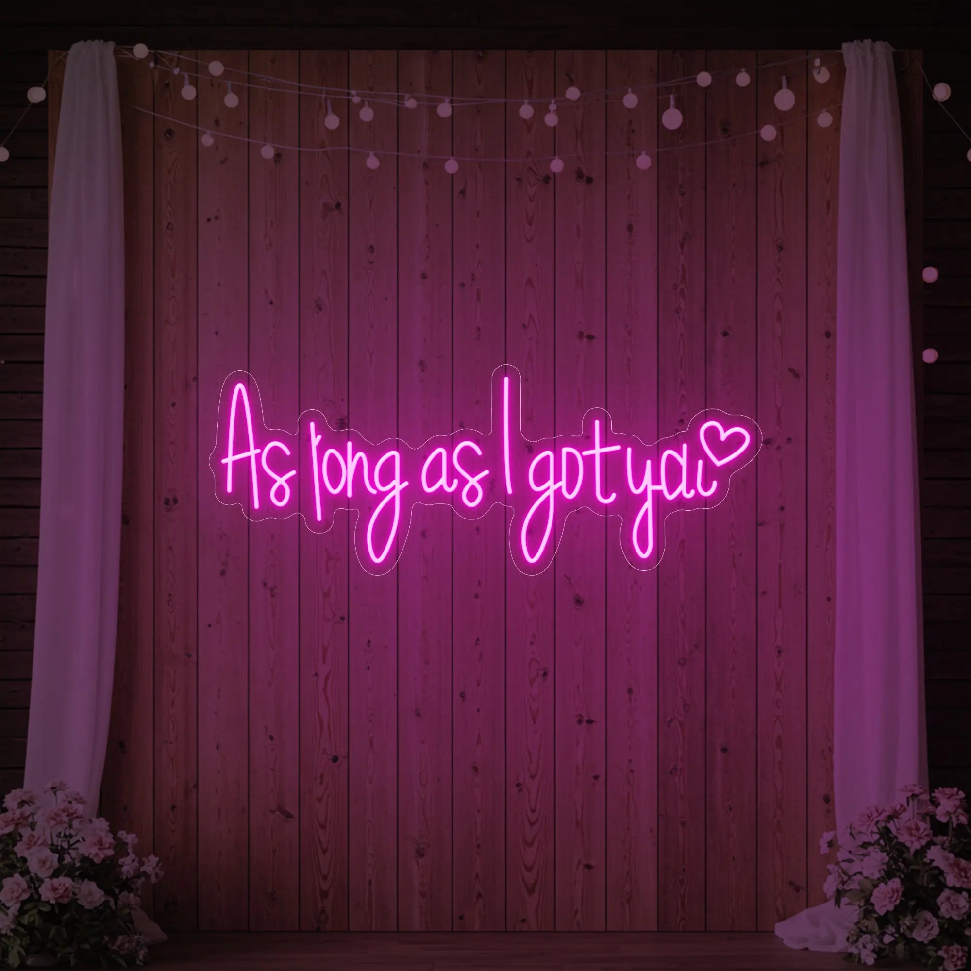 Photo of the 'As Long As I Got You' neon sign glowing in light pink against a styled interior wall.