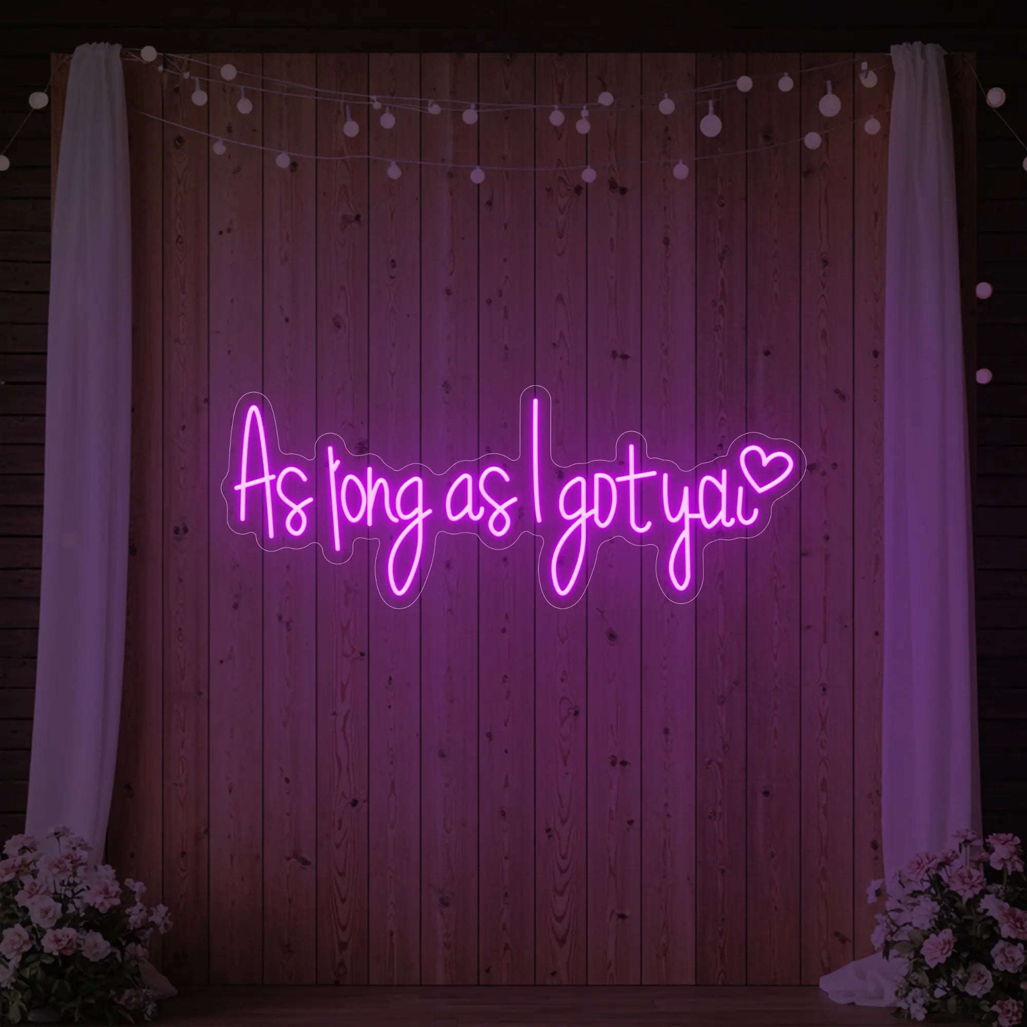 Photo of the 'As Long As I Got You' neon sign glowing in deep pink against a styled interior wall.