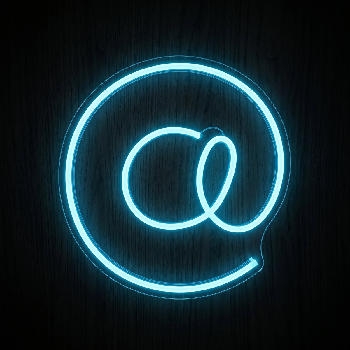 At Symbol LED Neon Sign featuring a bright blue glowing @ symbol on a clear acrylic backing.