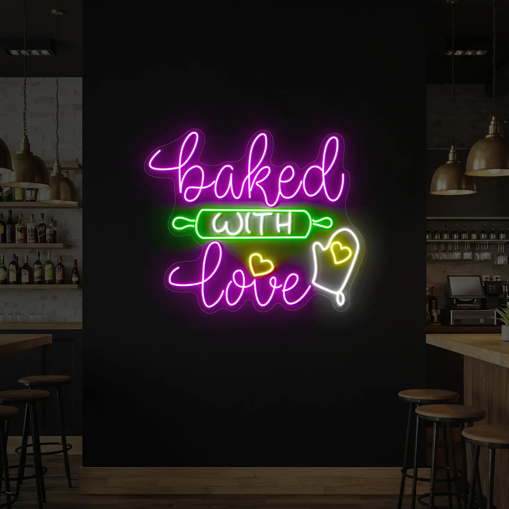 Photo of the 'Baked With Love' neon sign glowing in cool white, purple, green and yellow neon against a styled interior wall.