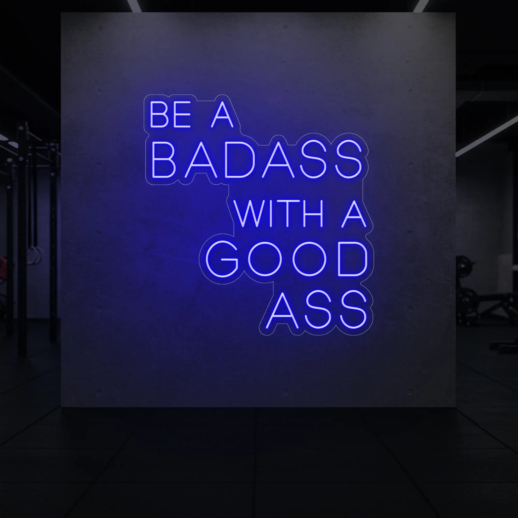 'Be a Badass With a Good Ass' neon sign glowing in deep blue against a styled interior wall.