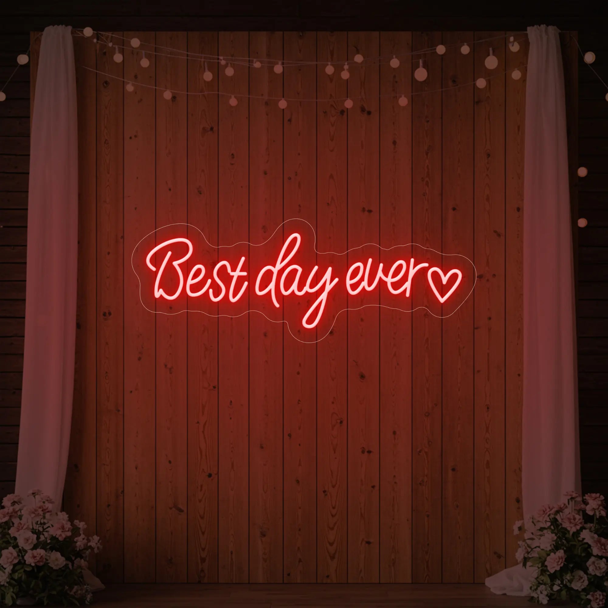 Photo of the 'Best Day Ever Heart' neon sign glowing in red against a styled interior wall.