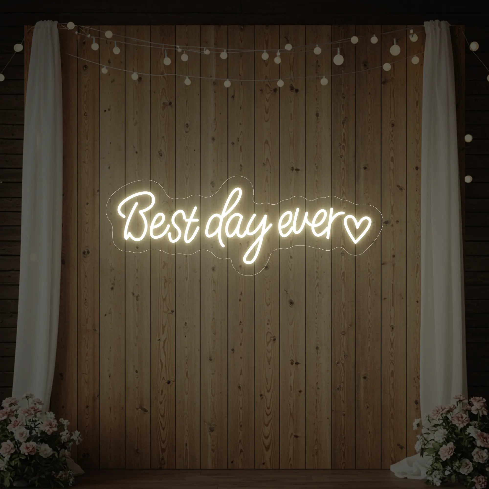 Photo of the 'Best Day Ever Heart' neon sign glowing in warm white against a styled interior wall.