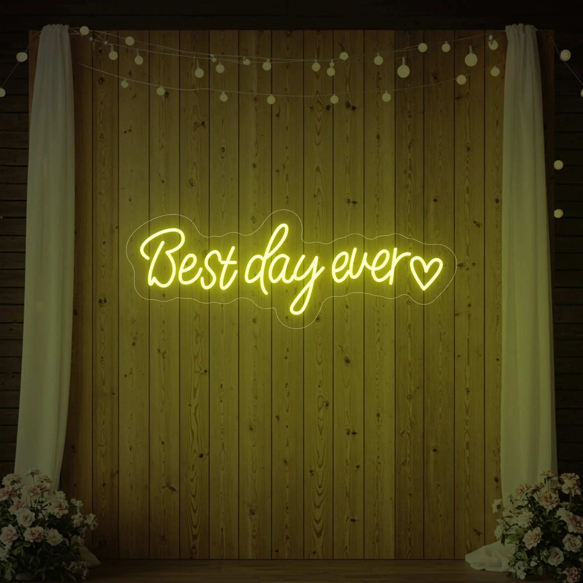 Photo of the 'Best Day Ever Heart' neon sign glowing in lemon yellow against a styled interior wall.