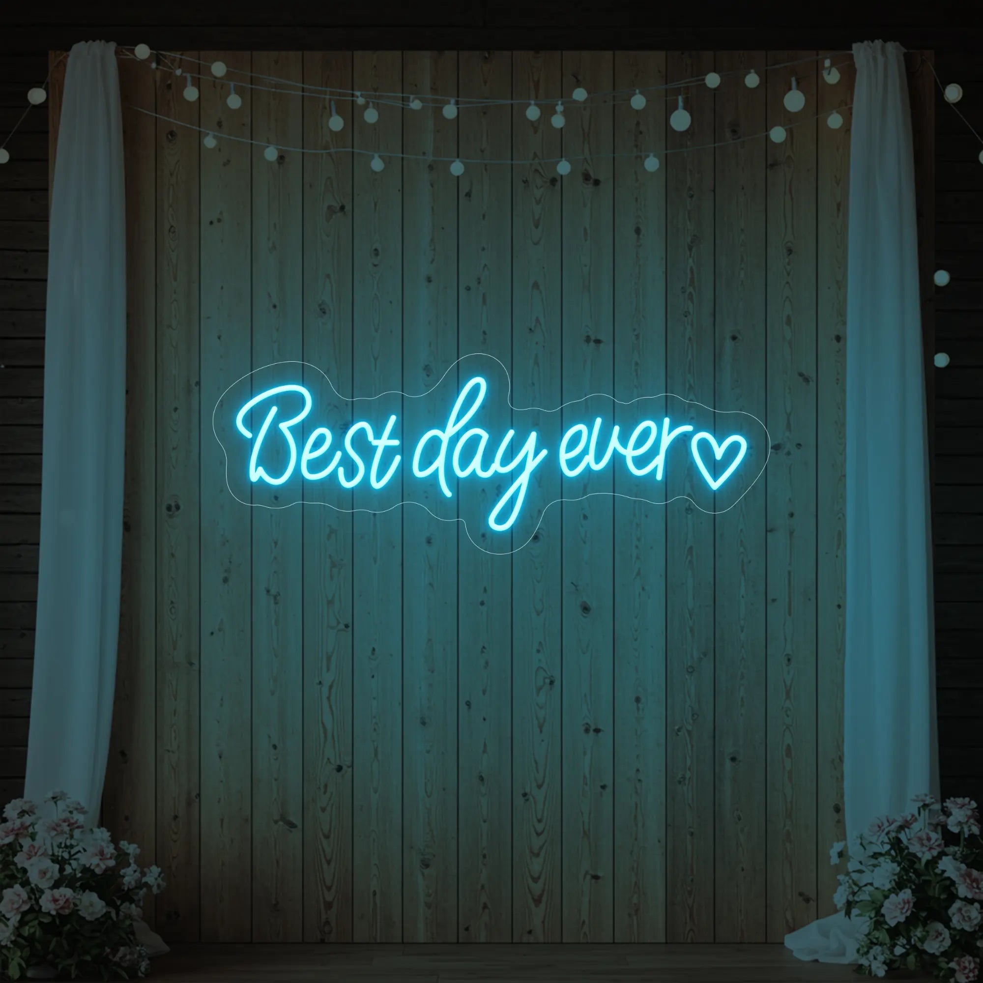 Photo of the 'Best Day Ever Heart' neon sign glowing in ice blue against a styled interior wall.
