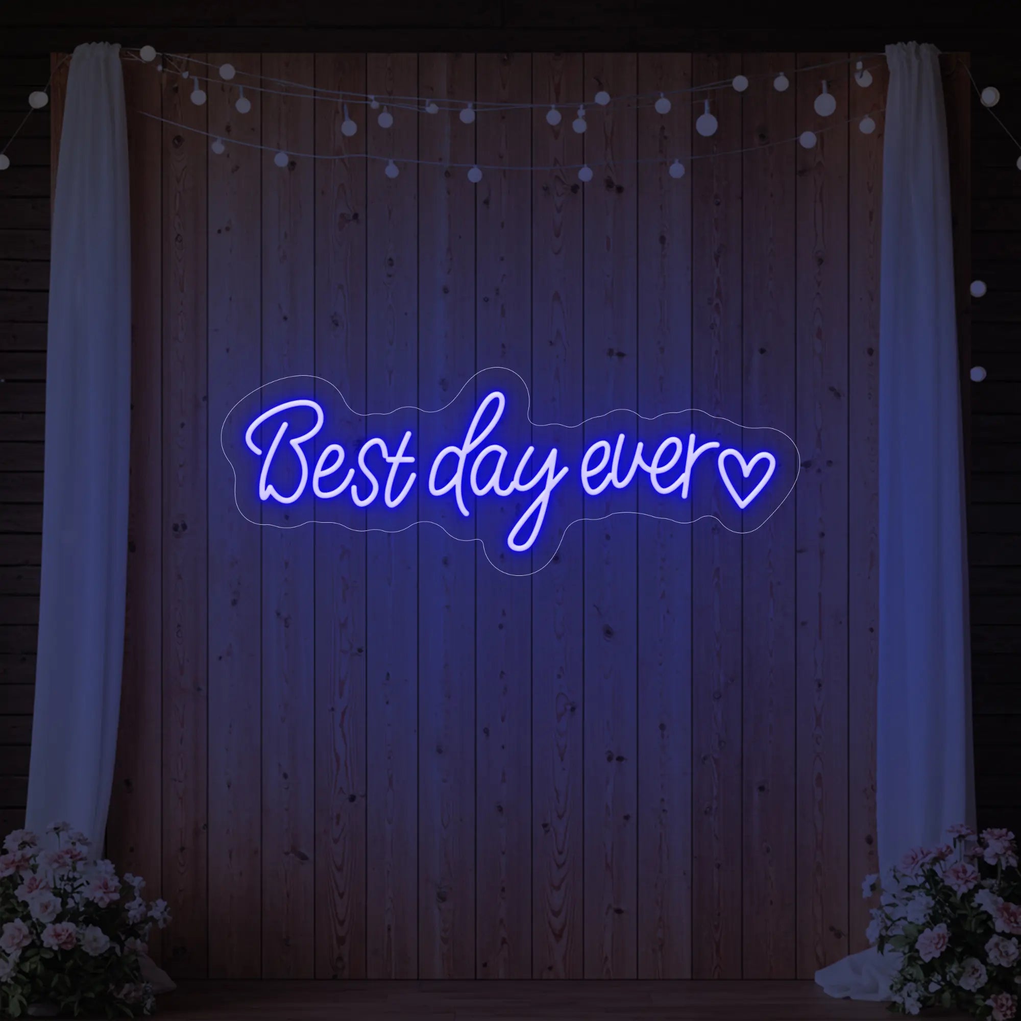 Photo of the 'Best Day Ever Heart' neon sign glowing in deep blue against a styled interior wall.
