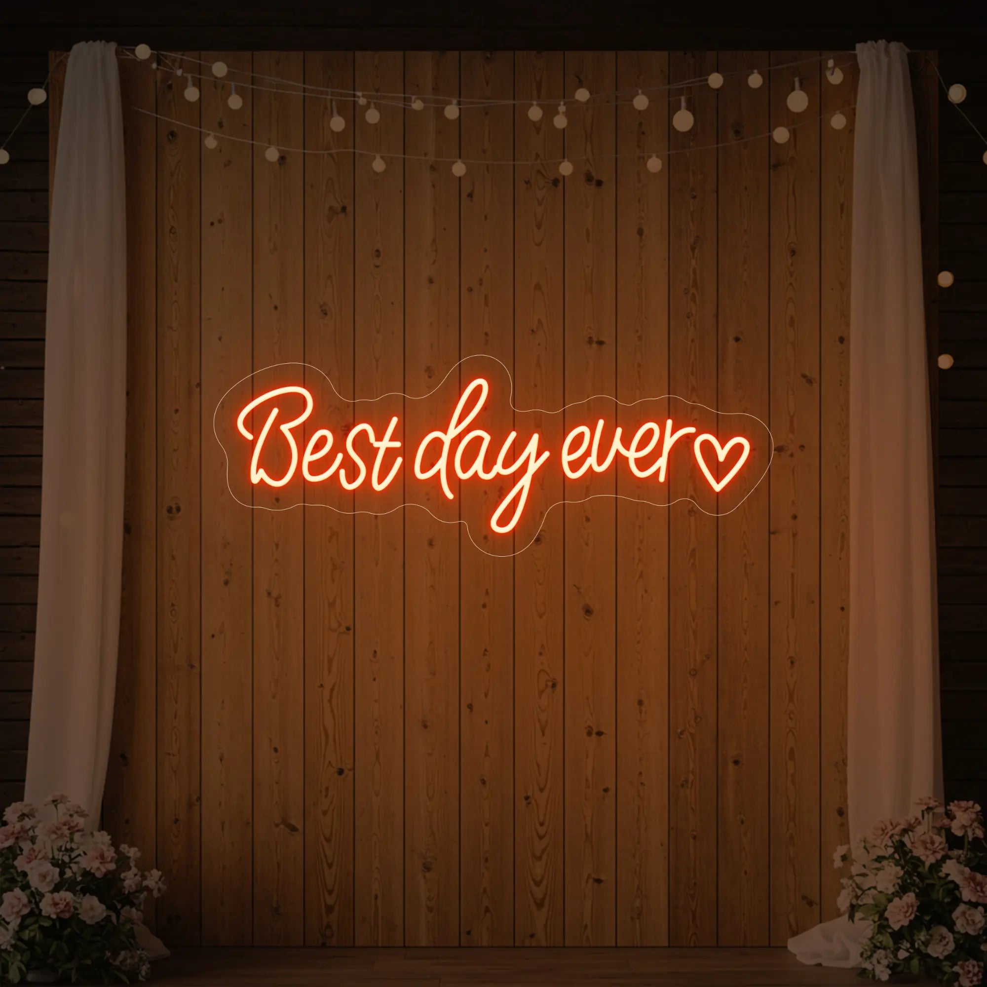 Photo of the 'Best Day Ever Heart' neon sign glowing in golden yellow against a styled interior wall.