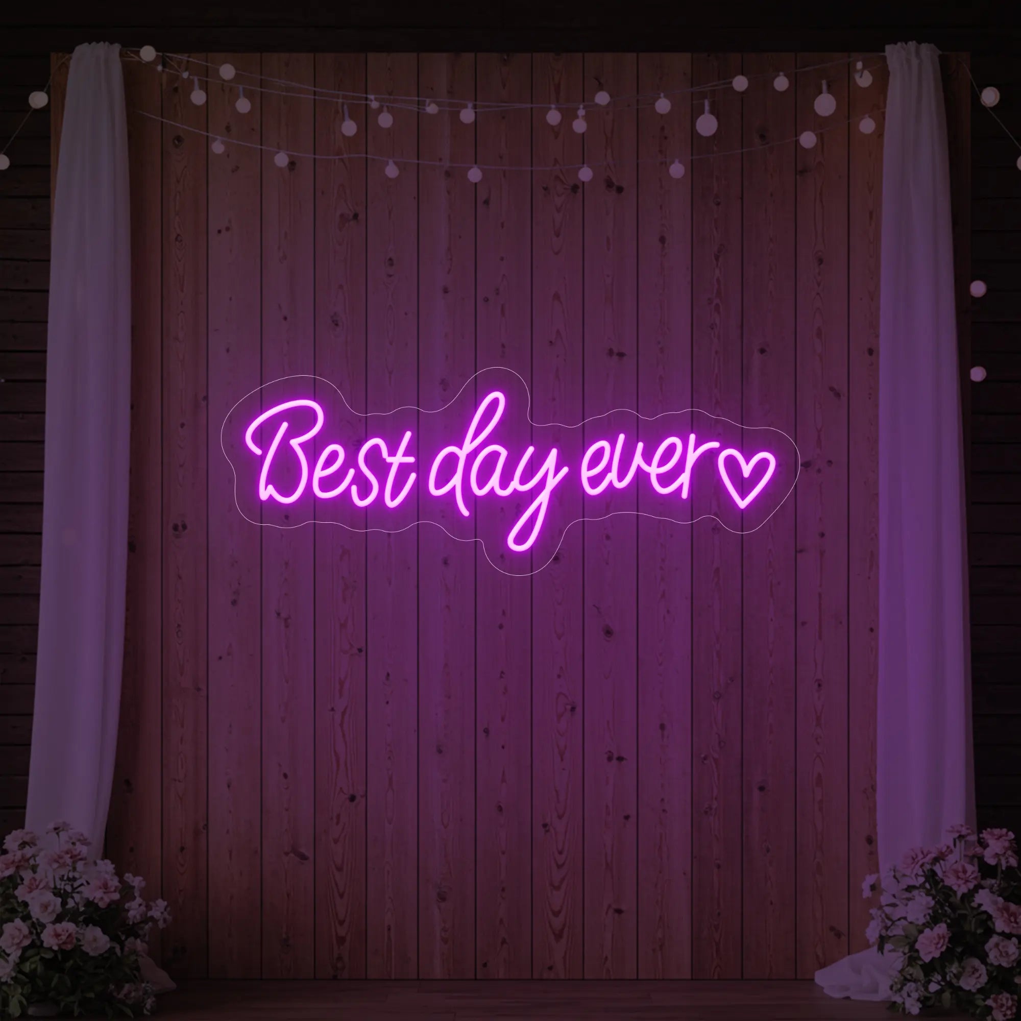 Photo of the 'Best Day Ever Heart' neon sign glowing in deep pink against a styled interior wall.