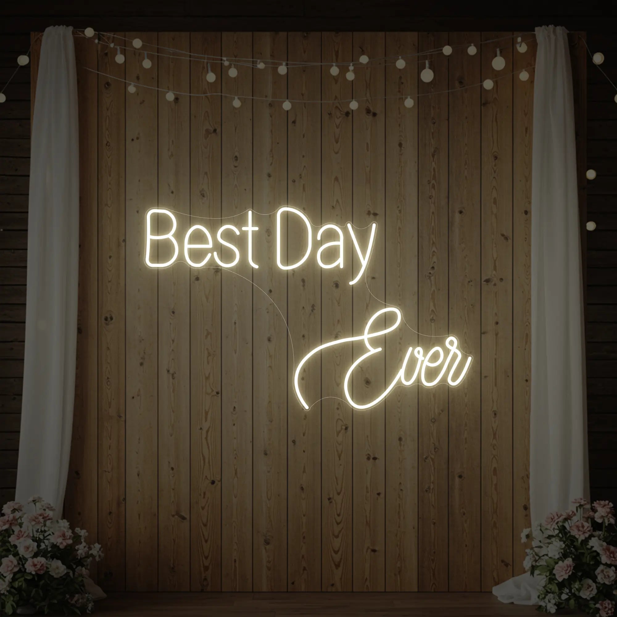 Photo of the 'Best Day Ever' neon sign glowing in warm white against a styled interior wall.