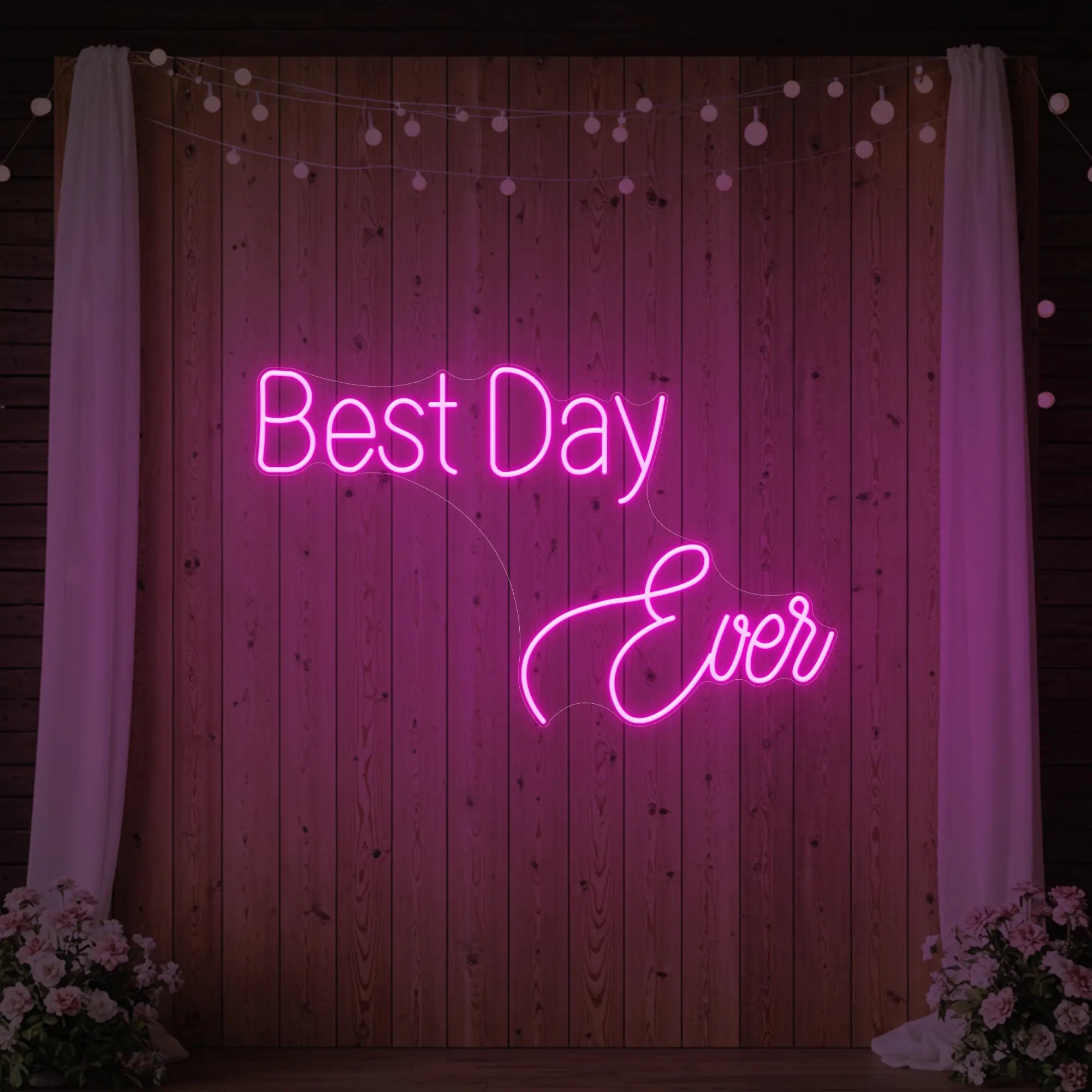 Photo of the 'Best Day Ever' neon sign glowing in light pink against a styled interior wall.