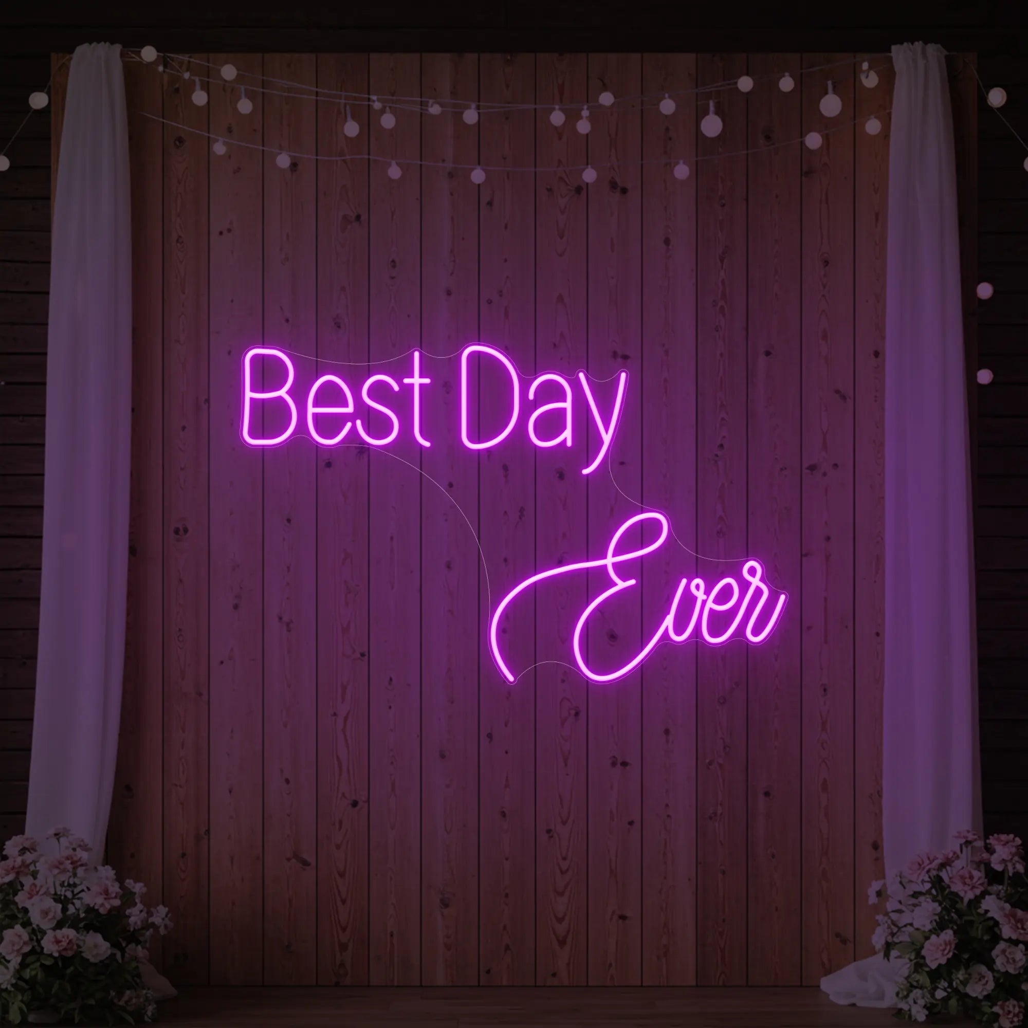 Photo of the 'Best Day Ever' neon sign glowing in deep pink against a styled interior wall.