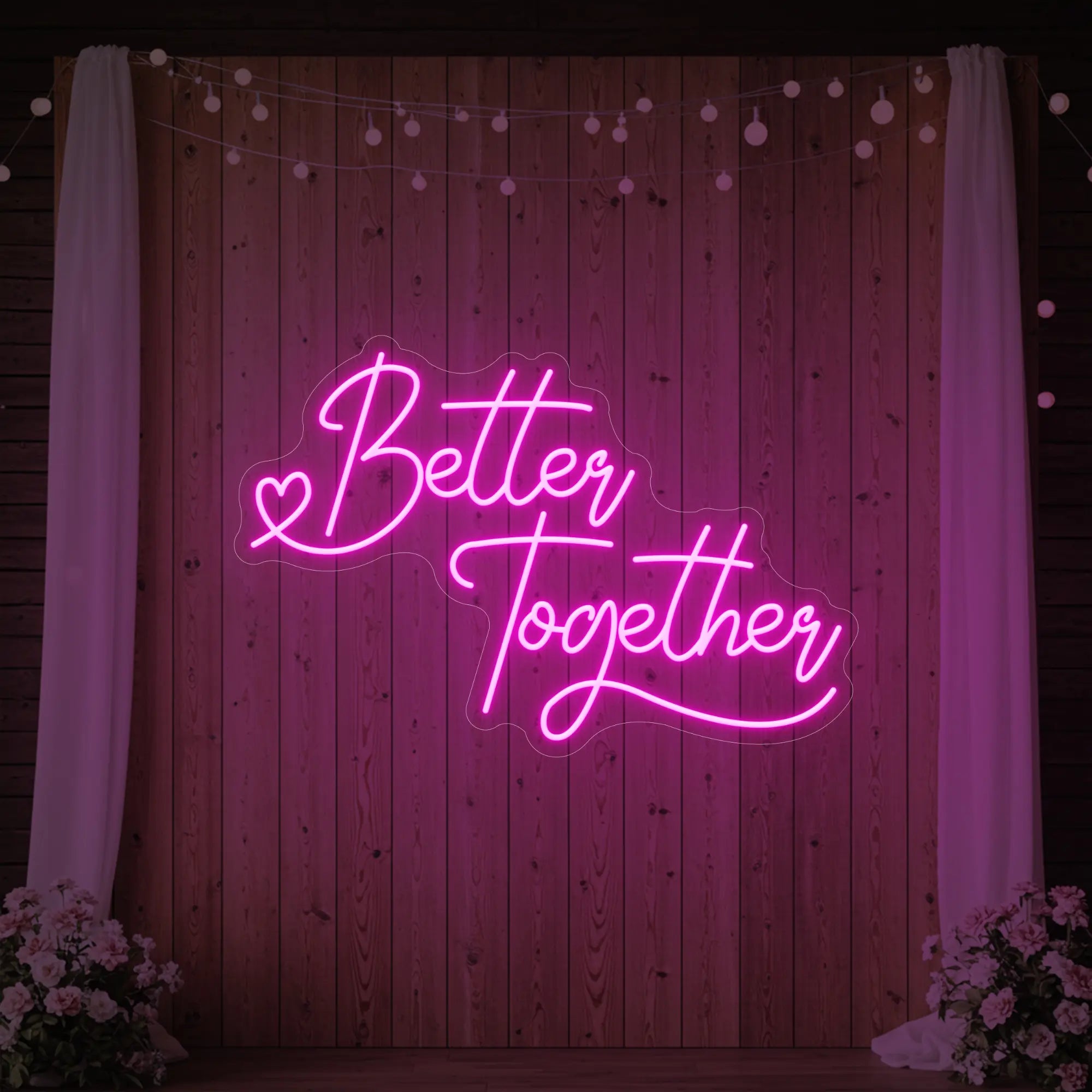 Photo of the 'Better Together' neon sign glowing in light pink against a styled interior wall.