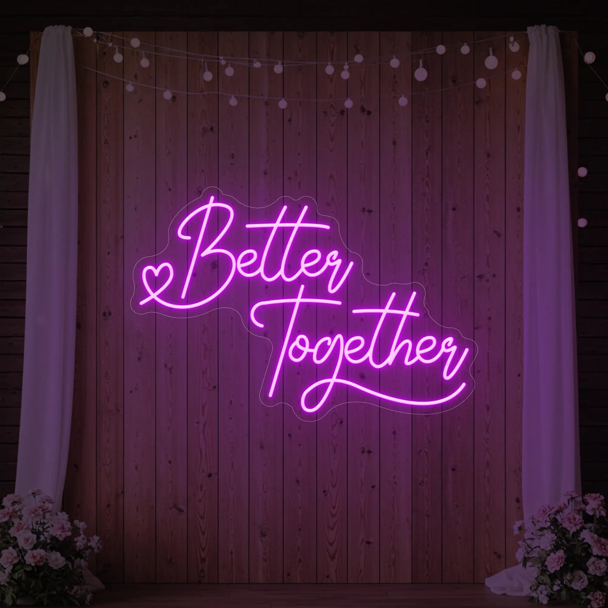Photo of the 'Better Together' neon sign glowing in deep pink against a styled interior wall.