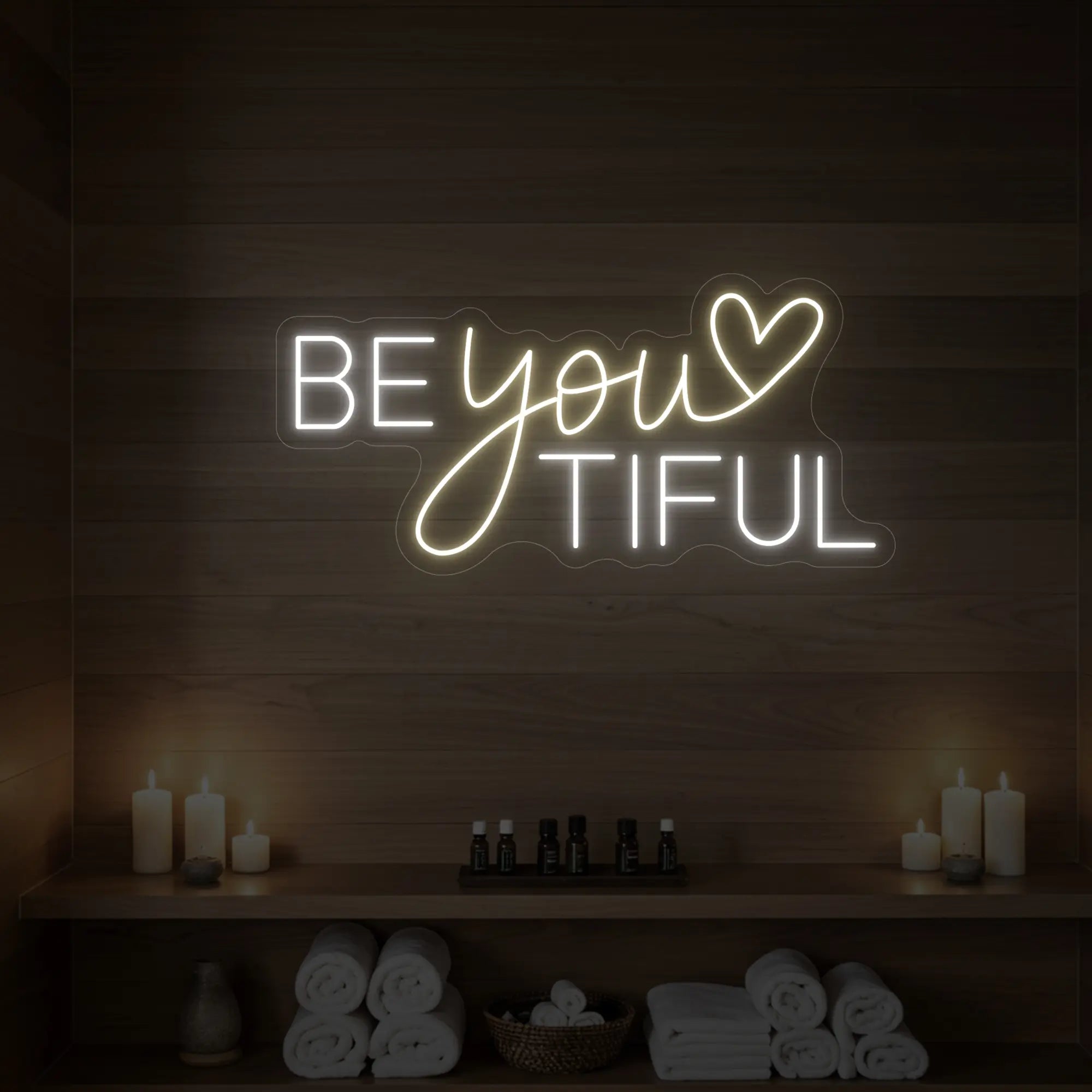 Photo of the 'BEYOUtiful' neon sign glowing in warm white against a styled interior wall.