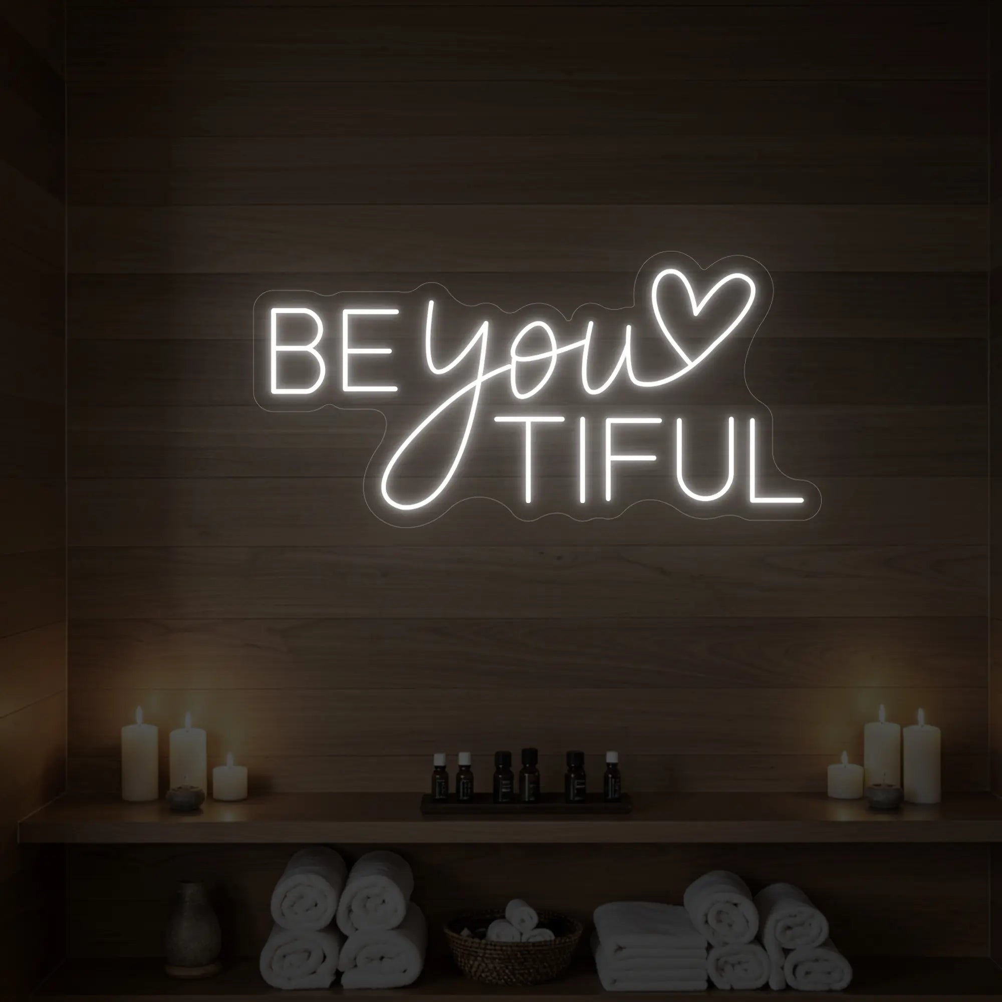 Photo of the 'BEYOUtiful' neon sign glowing in cool white against a styled interior wall.