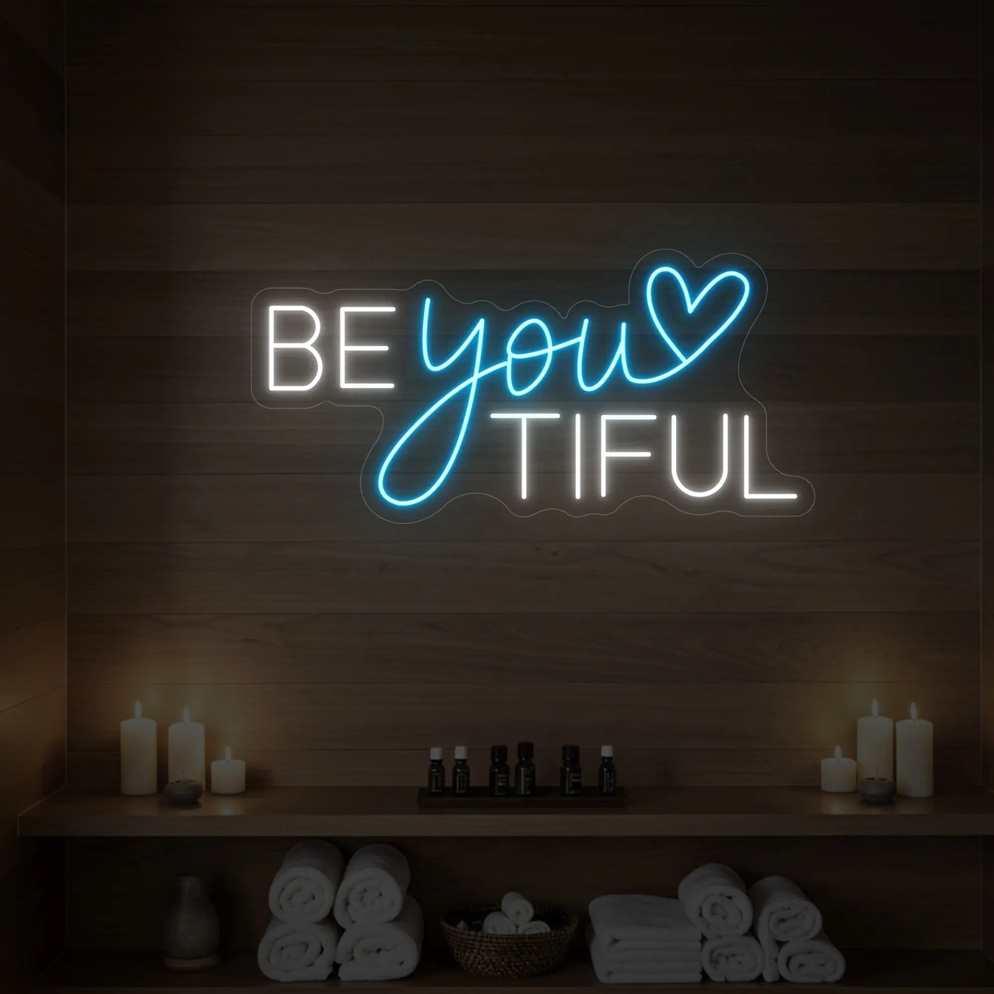 Photo of the 'BEYOUtiful' neon sign glowing in ice blue against a styled interior wall.
