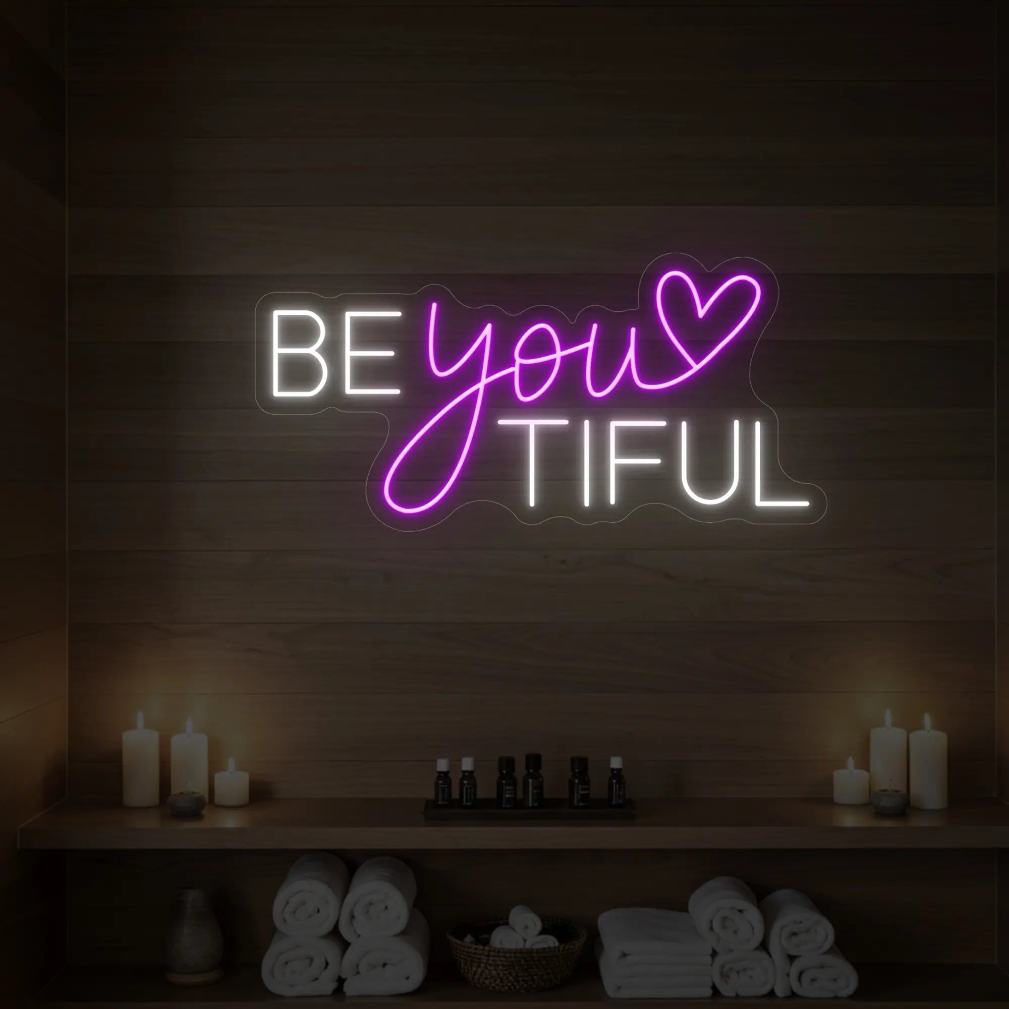 Photo of the 'BEYOUtiful' neon sign glowing in deep pink against a styled interior wall.