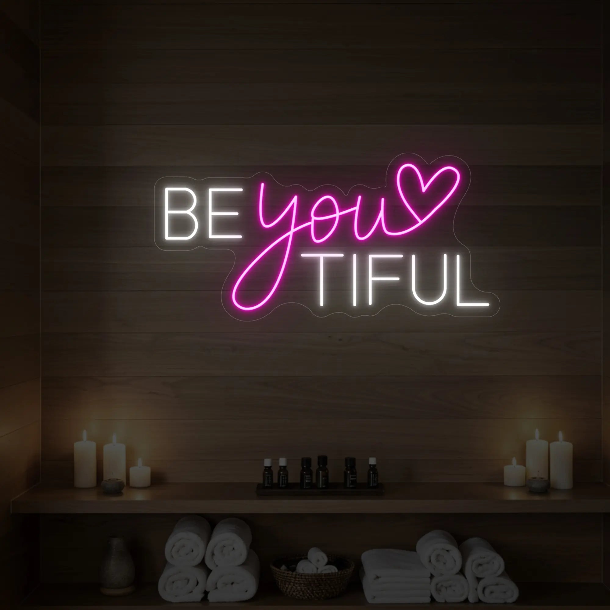 Photo of the 'BEYOUtiful' neon sign glowing in light pink against a styled interior wall.
