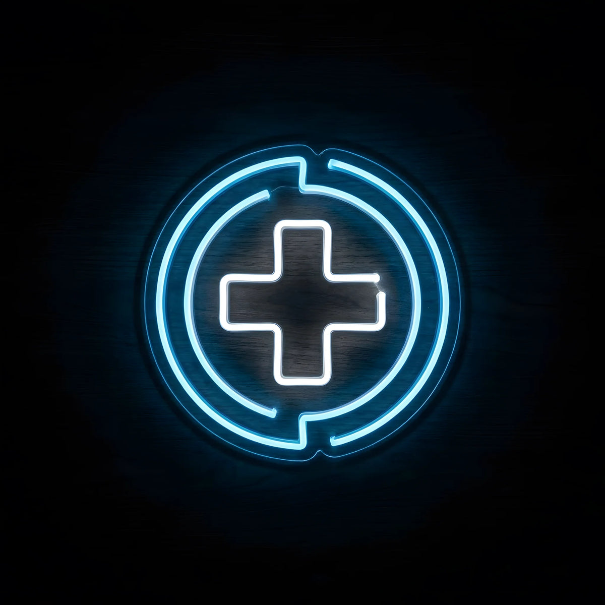 Blue Medical Cross Emblem LED Neon Sign featuring a glowing white medical cross surrounded by electric-blue circular neon accents on clear acrylic backing against a dark wooden wall.