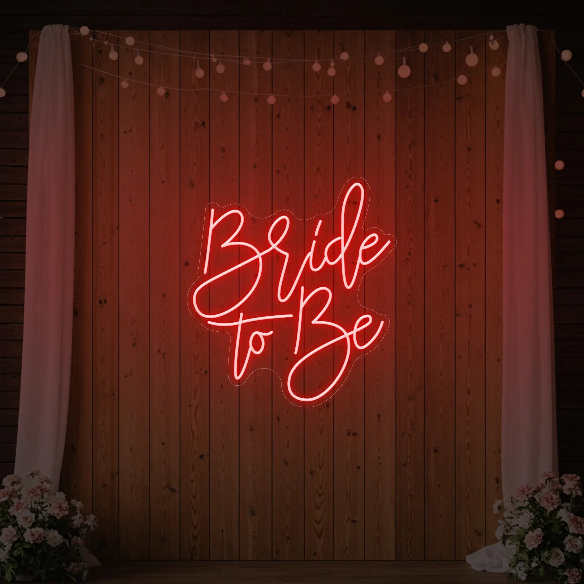 Photo of the 'Bride To Be' neon sign glowing in red against a styled interior wall.