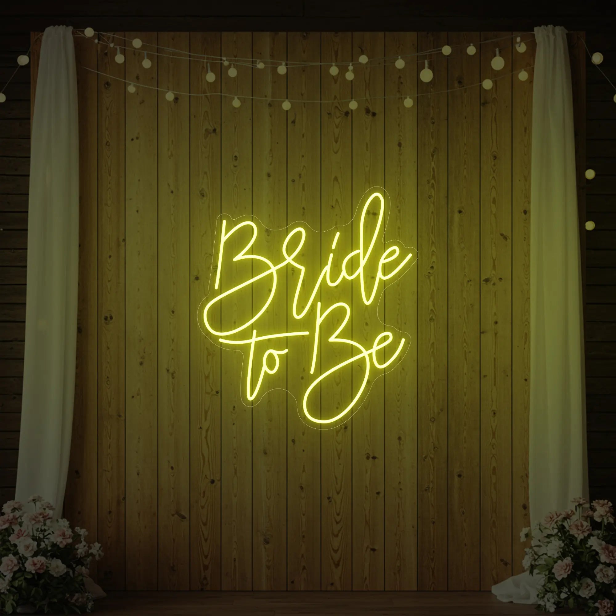 Photo of the 'Bride To Be' neon sign glowing in lemon yellow against a styled interior wall.