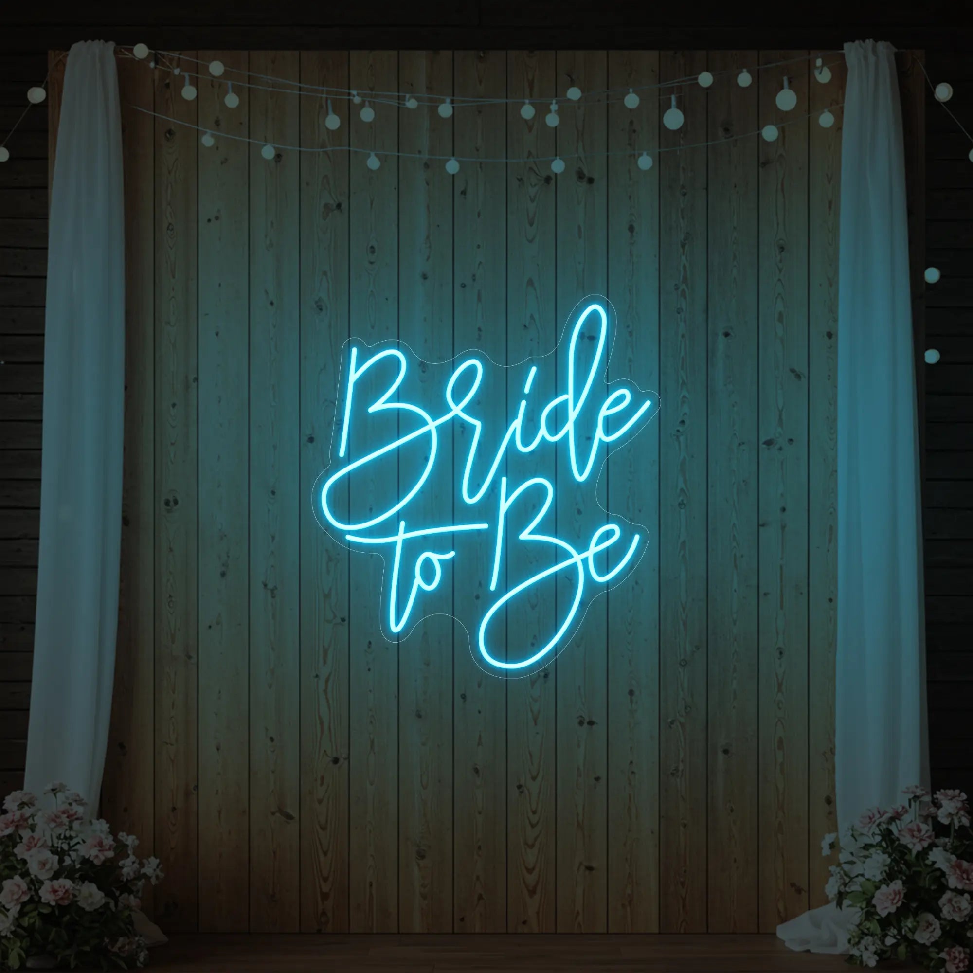 Photo of the 'Bride To Be' neon sign glowing in ice blue against a styled interior wall.
