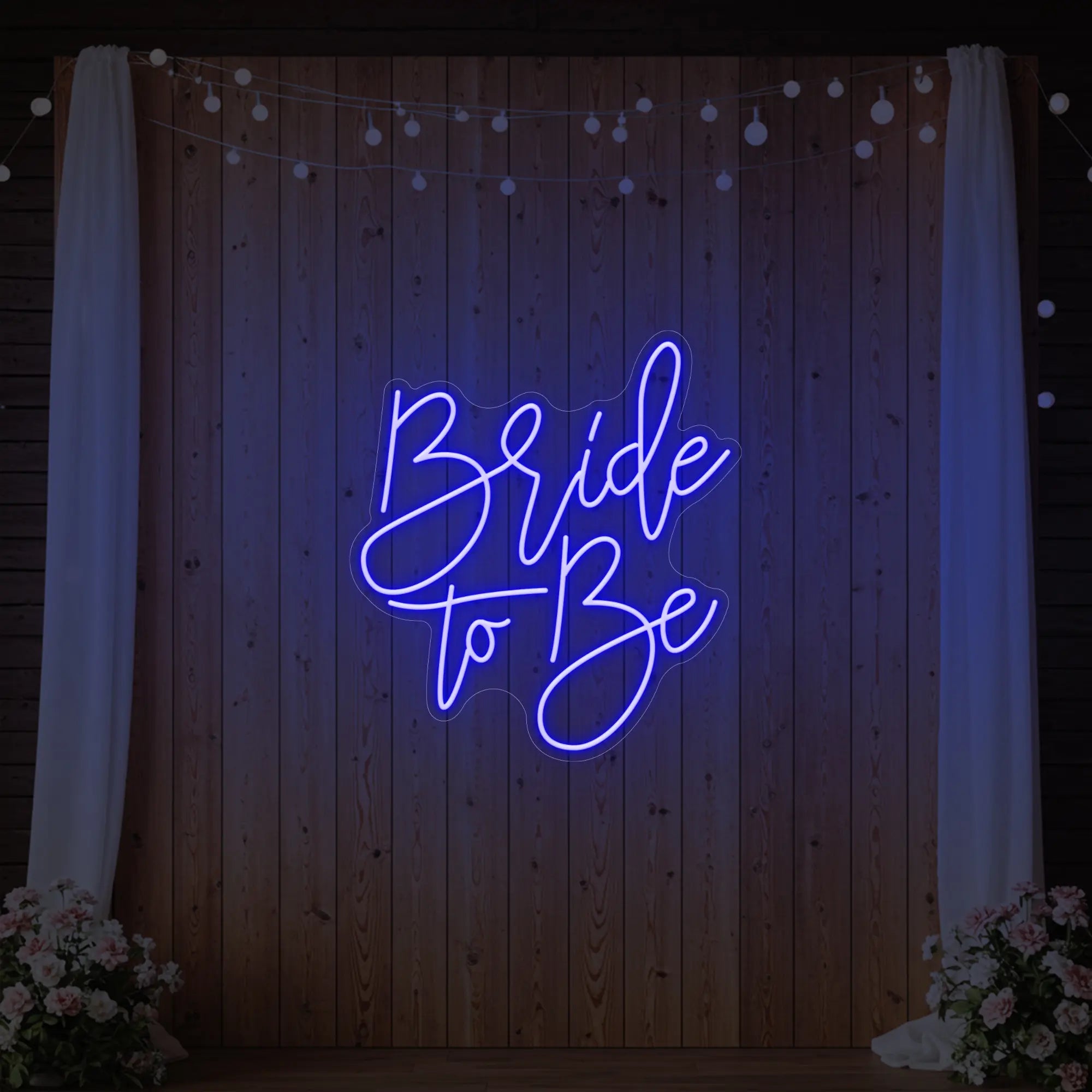 Photo of the 'Bride To Be' neon sign glowing in deep blue against a styled interior wall.
