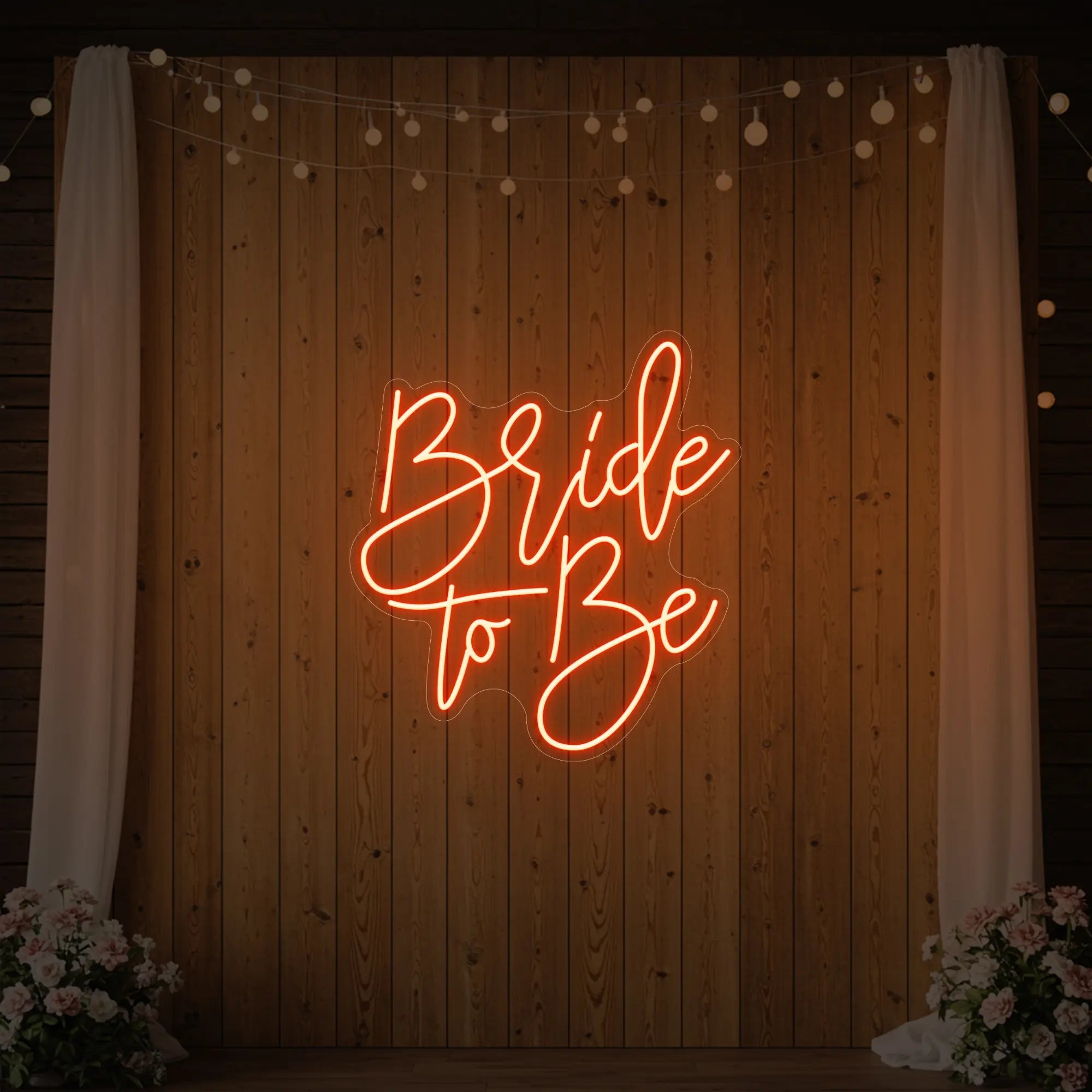 Photo of the 'Bride To Be' neon sign glowing in golden yellow against a styled interior wall.