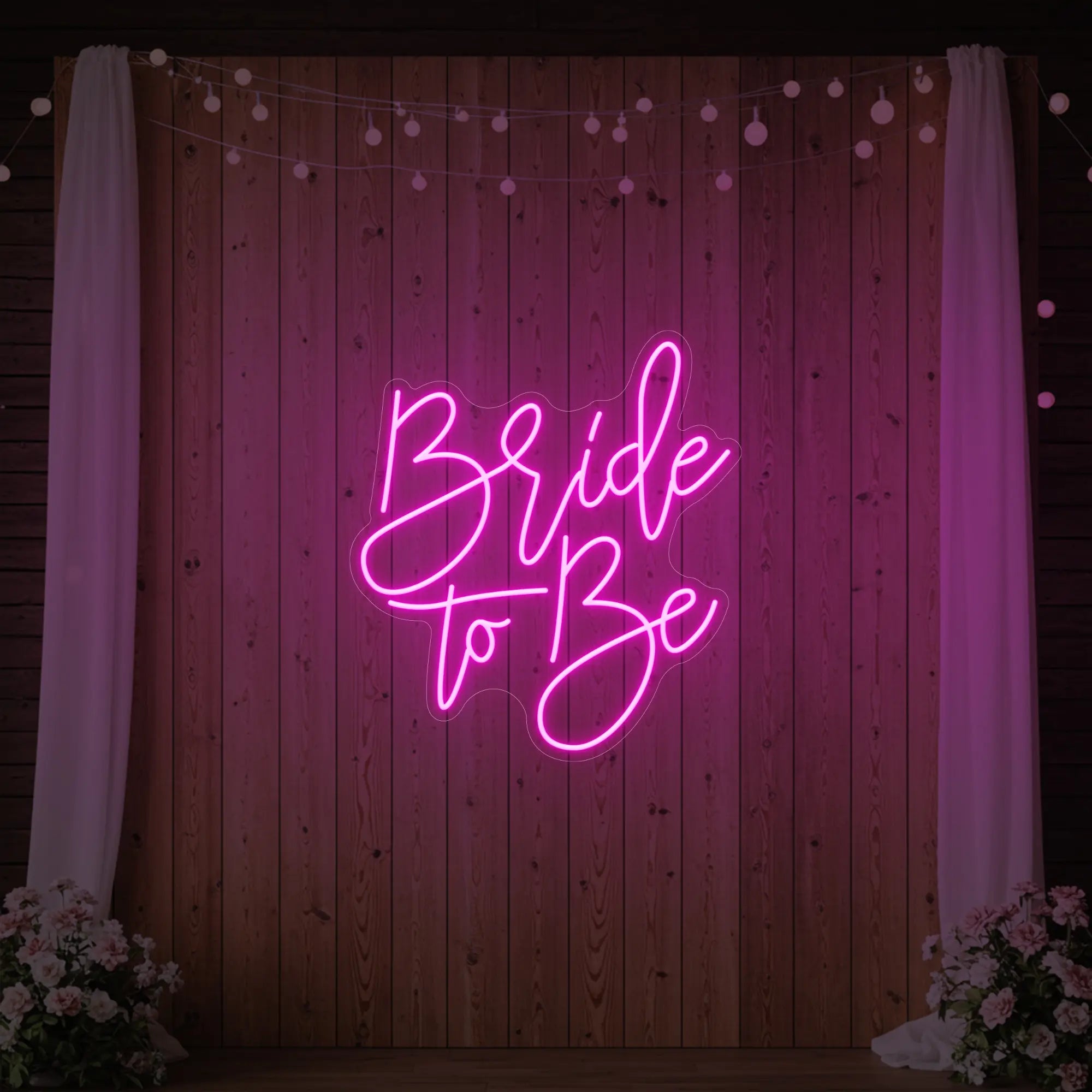 Photo of the 'Bride To Be' neon sign glowing in light pink against a styled interior wall.