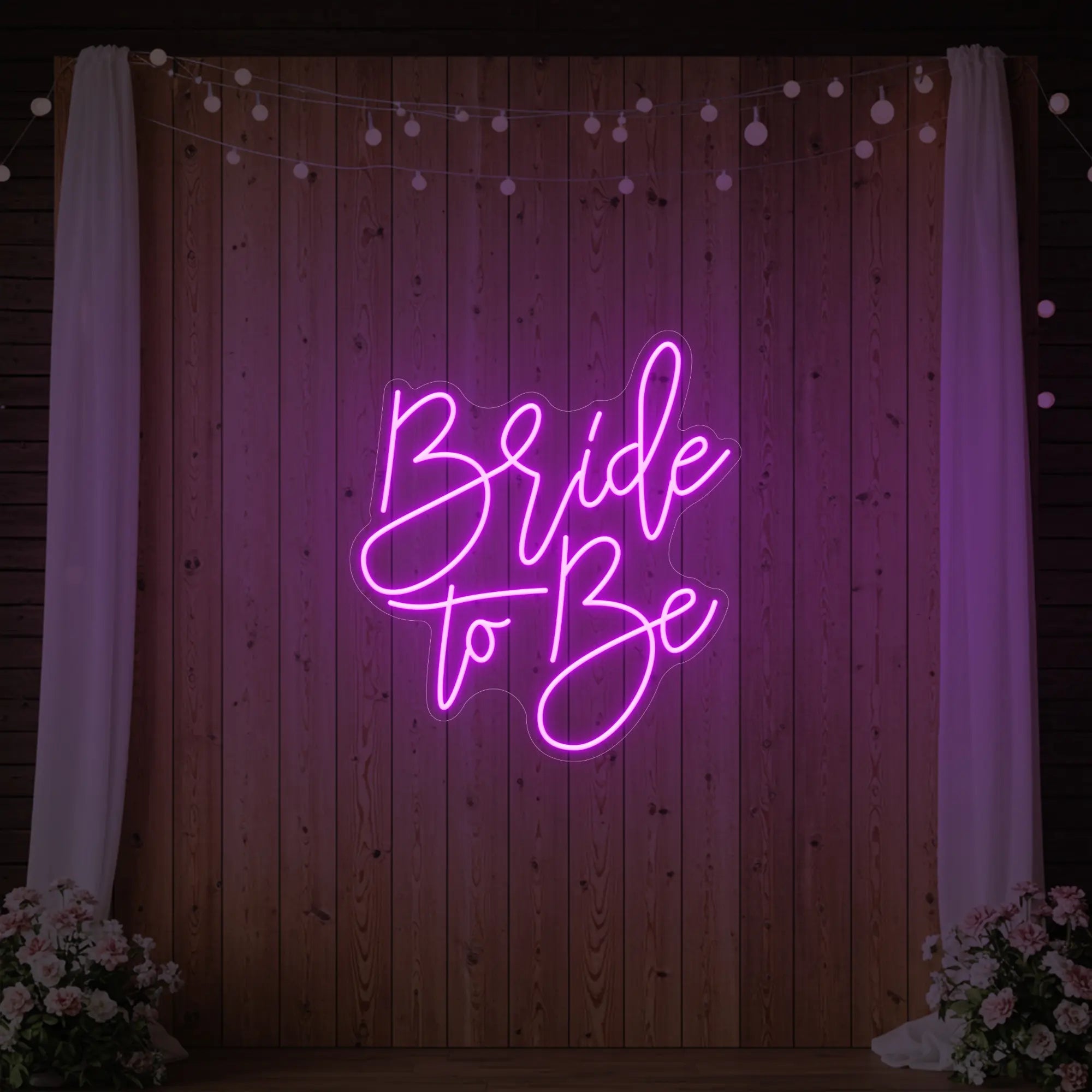 Photo of the 'Bride To Be' neon sign glowing in deep pink against a styled interior wall.