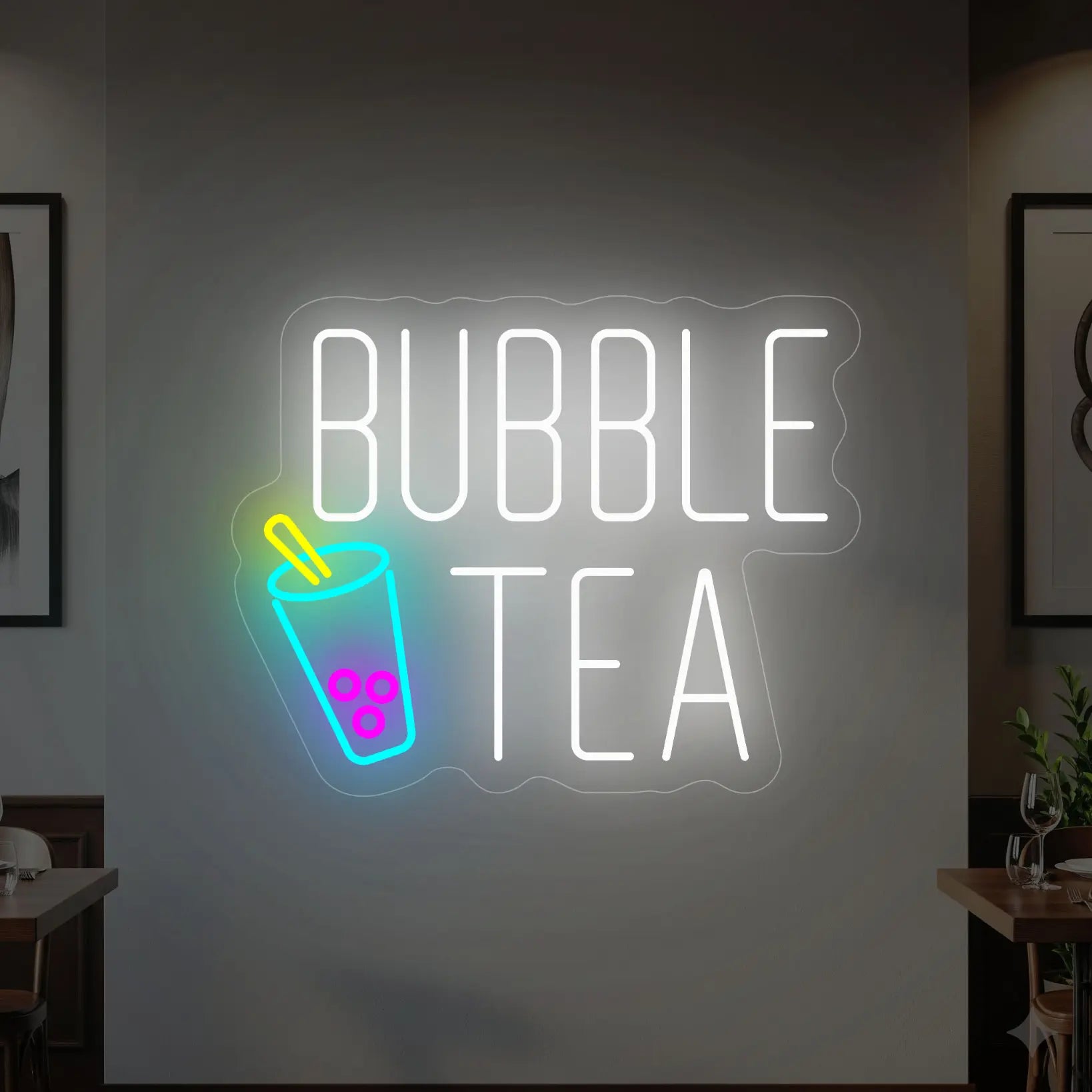 Photo of the 'BUBBLE TEA' neon sign glowing in multi-color against a styled interior wall.