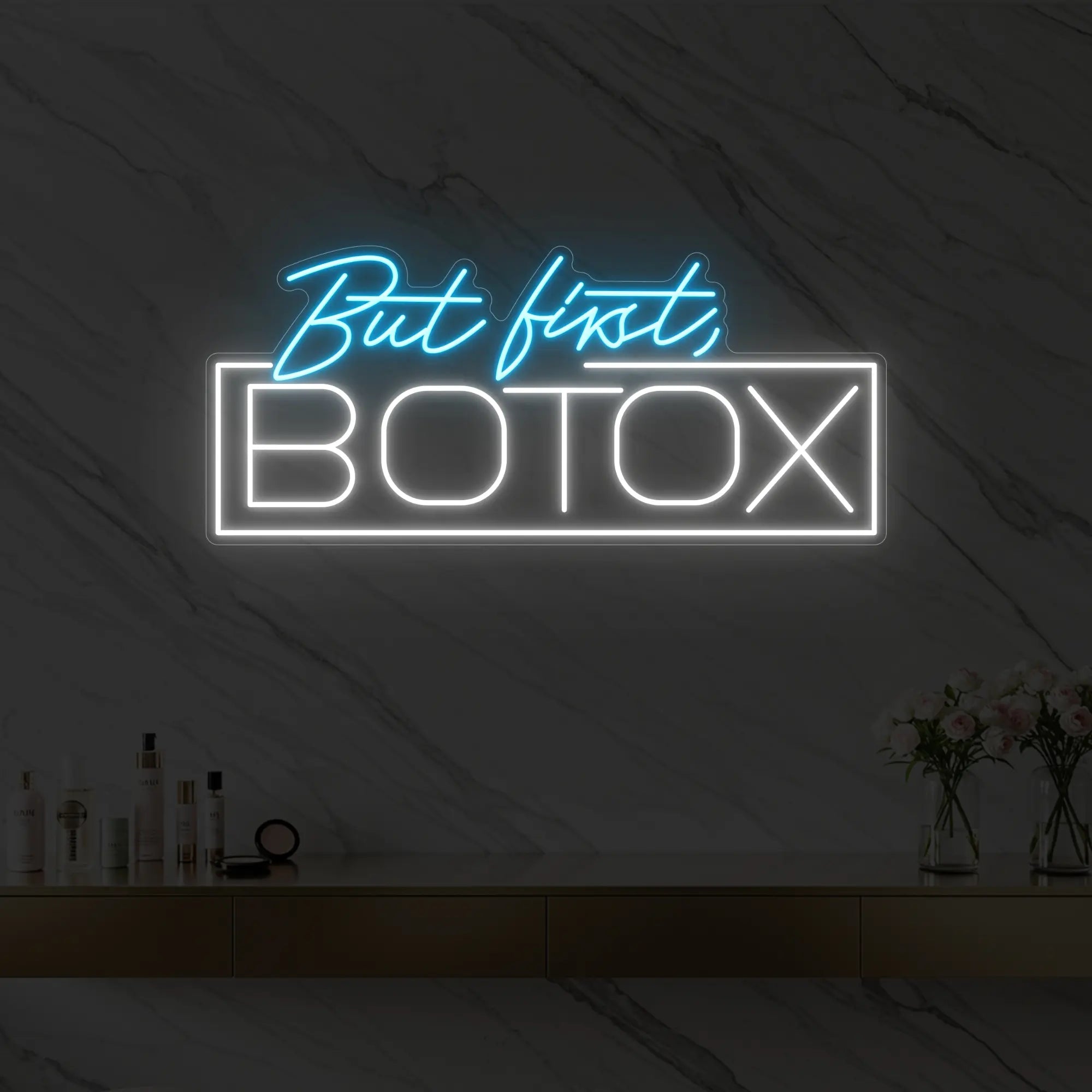 Photo of the 'But first, BOTOX' neon sign glowing in ice blue against a styled interior wall.