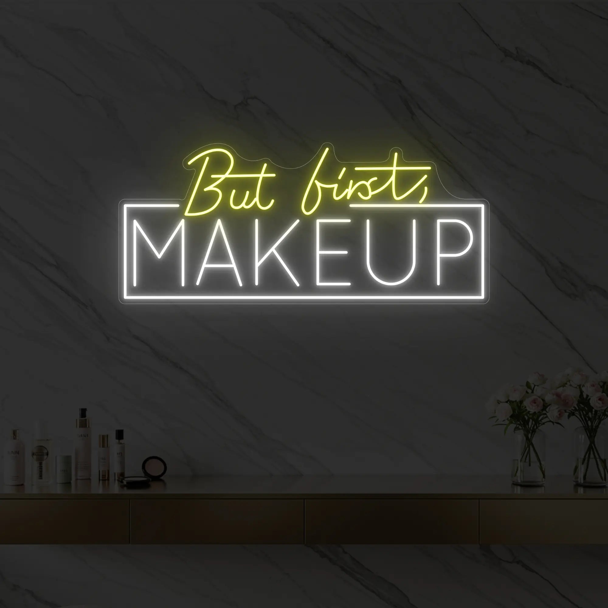 Photo of the 'But first, MAKEUP' neon sign glowing in lemon yellow against a styled interior wall.