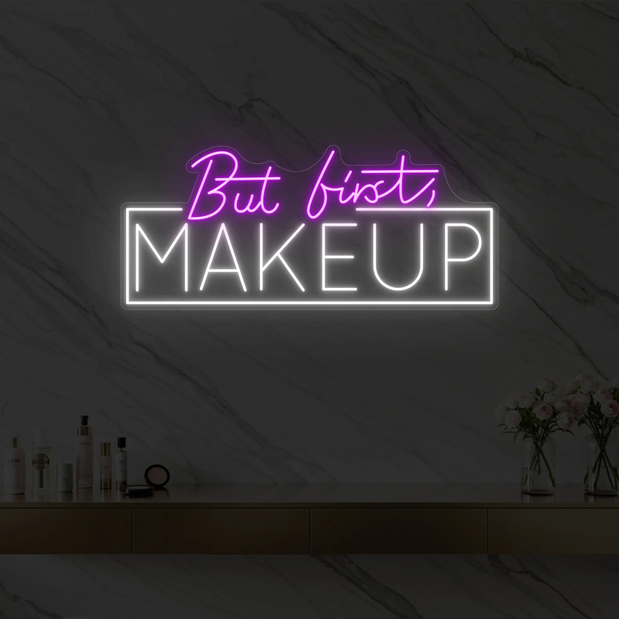 Photo of the 'But first, MAKEUP' neon sign glowing in deep pink against a styled interior wall.